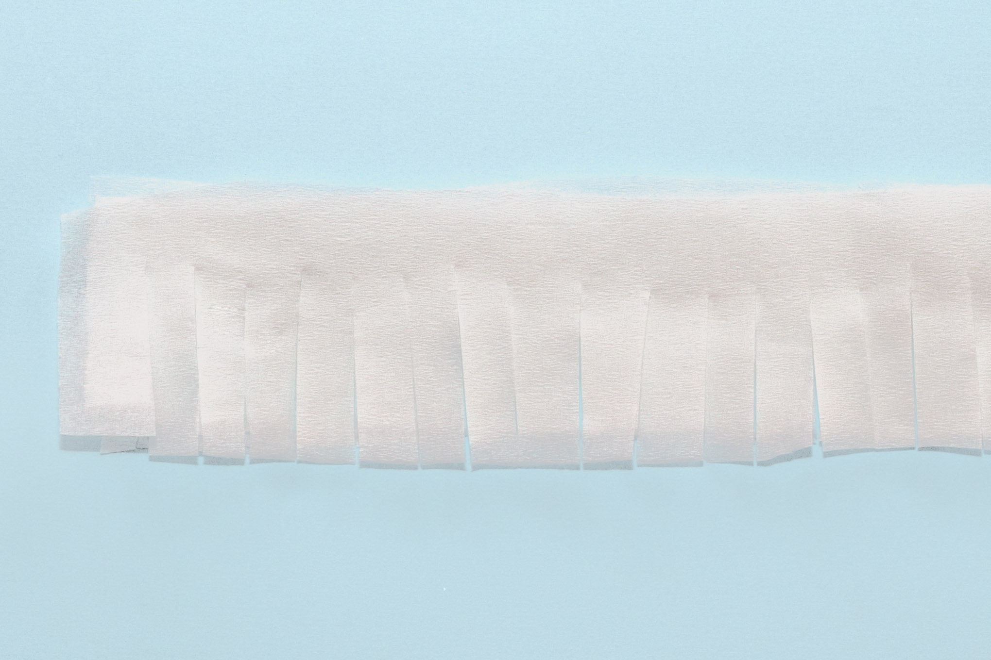 Step 4: Once the paper mache is dry, paint with white paint to cover the newspaper. Cut the crepe paper into strips about 10cm wide. Then, cut into these strips at 1cm intervals, leaving about 1cm at the top (as shown in the image above.) Repeat this until you have lots and lots of strips of crepe paper!