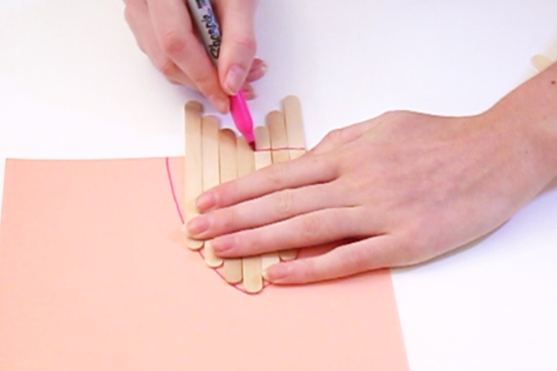 Step 2 Place the lolly sticks inside the shape you have drawn, with the tops of the sticks lining up with the edge of the shape. Then draw a line on the sticks where the end of the paper is. Then, place two more sticks across the others horizontally, and draw lines on these where the side of the other sticks are.