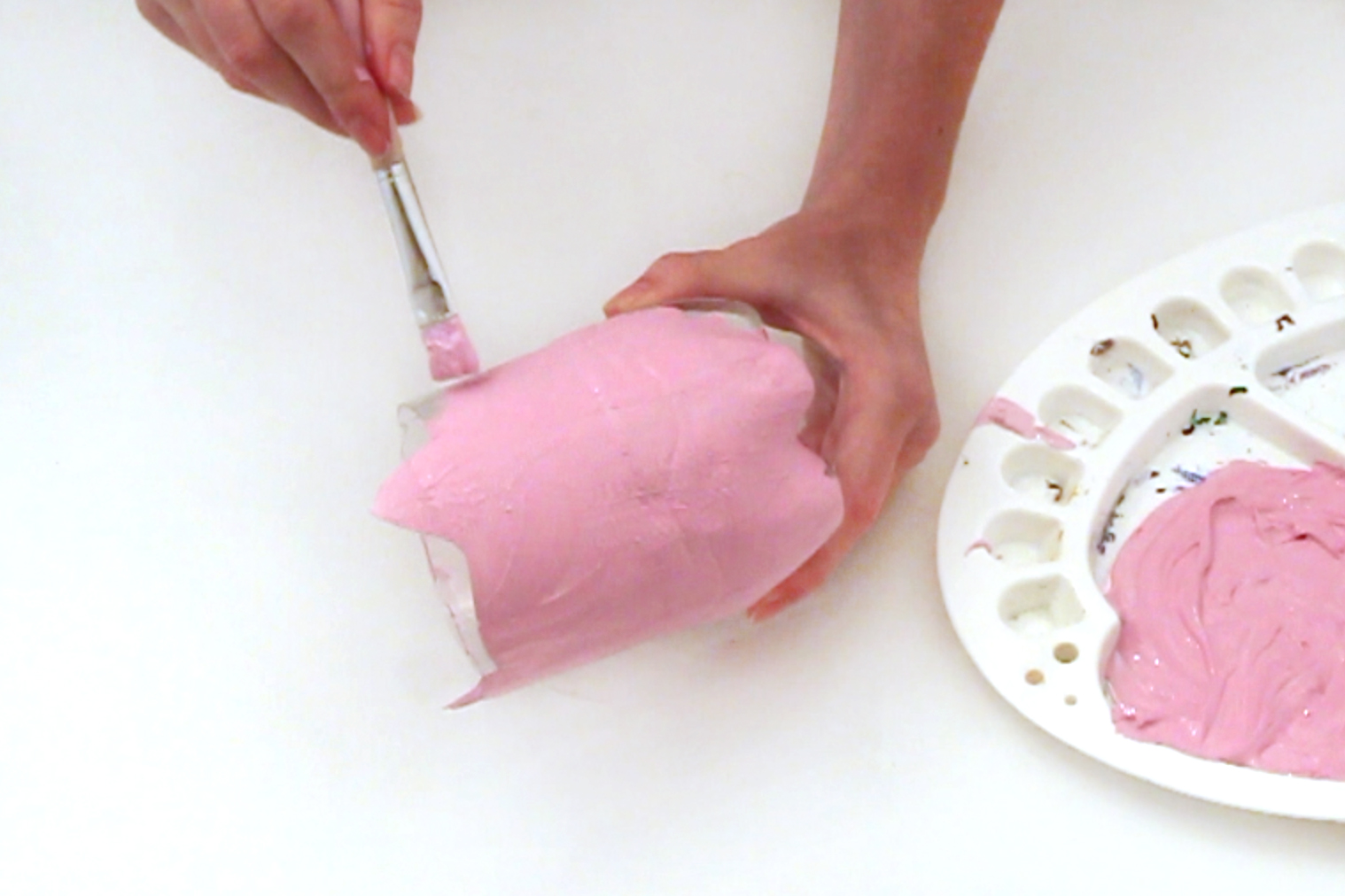 Step 2 Mix the pink and white paint together until you have a pig shade of pink. Then paint the whole of the outside of the plastic bottle. Leave to dry.