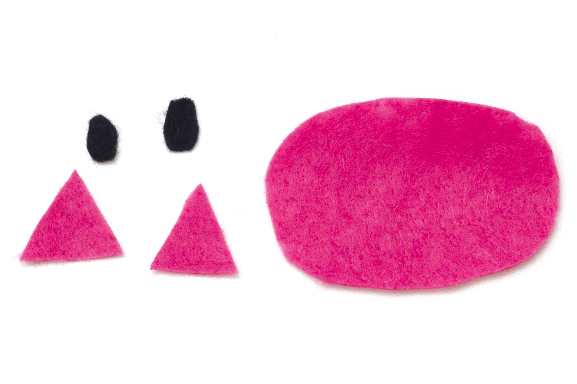 Step 3 Cut an oval shape and two triangles out of the pink felt to make the nose and inner ears. Then cut two small ovals out of the black felt for the pig's nostrils. Glue the black shapes onto the pink oval.