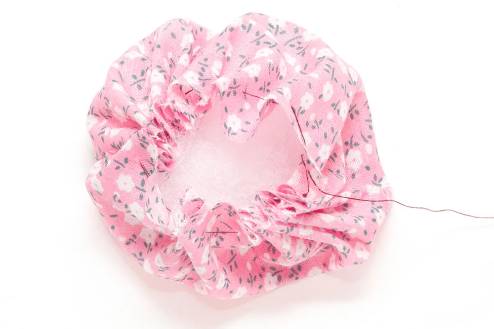 Step 2 Pull the end of the thread tightly so that the material pulls together to form a ball as shown in the photo above. This will form the shape of your pin cushion. Then, fill the material with stuffing and stitch up together to close the hole.