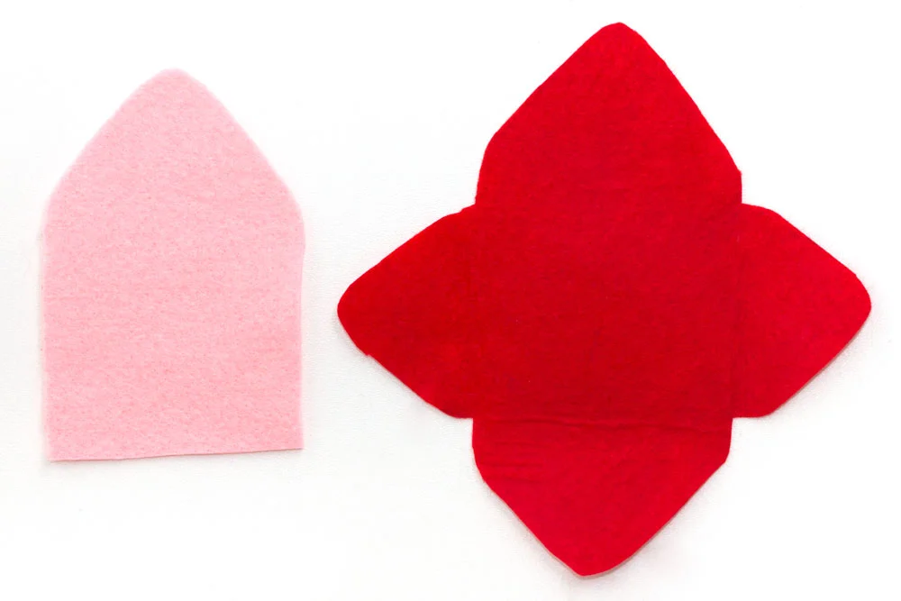 Step 1 Cut out the shapes shown in the photo above. They can be any size you like - I cut the red piece to about 16cm wide and that made an envelope that was approximately 10cm wide. So if you want it to be a bit bigger then cut these shapes slightly bigger! Make sure the pink felt shape is the same size as the upper triangle and middle section of the red piece of felt.