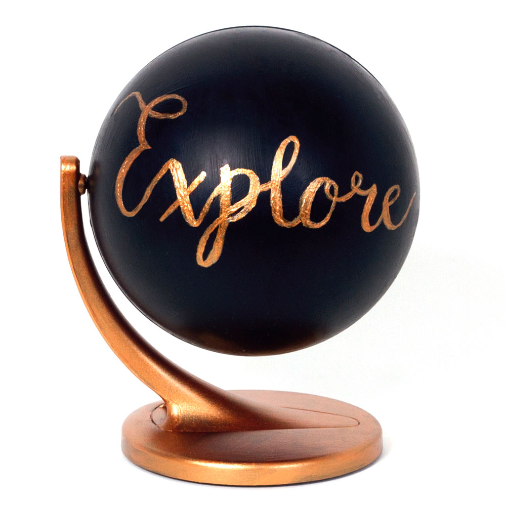 Step 3 With the gold or copper pen (or use the paint if you don't have a pen) carefully write the word of your choice onto the black globe. I wrote explore in a swirly font! If you are using paint you might have to do a few coats so it stands out on the black.