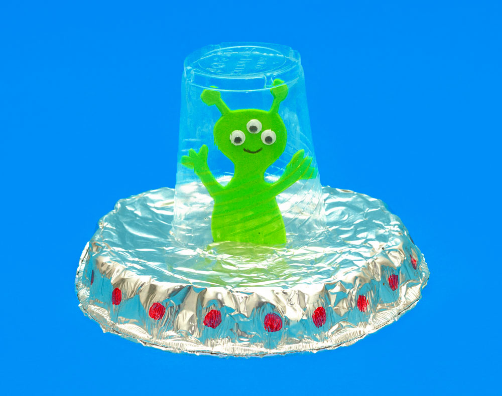 Step 2 Cut a slit in the centre of the foil dish and push the alien into it so it so the alien stands up. Glue around the rim of the plastic cup and place it on top of the alien, glueing it to the dish. The cup will form the window of the UFO! Then decorate the UFO however you wish to give it a space look, I drew some red circles around the edge. Subscribe to my newsletter to receive fun craft ideas, offers and freebies! Please note: this blog post contains affiliate links, however all opinions are my own and I only link to products that I personally use and recommend.