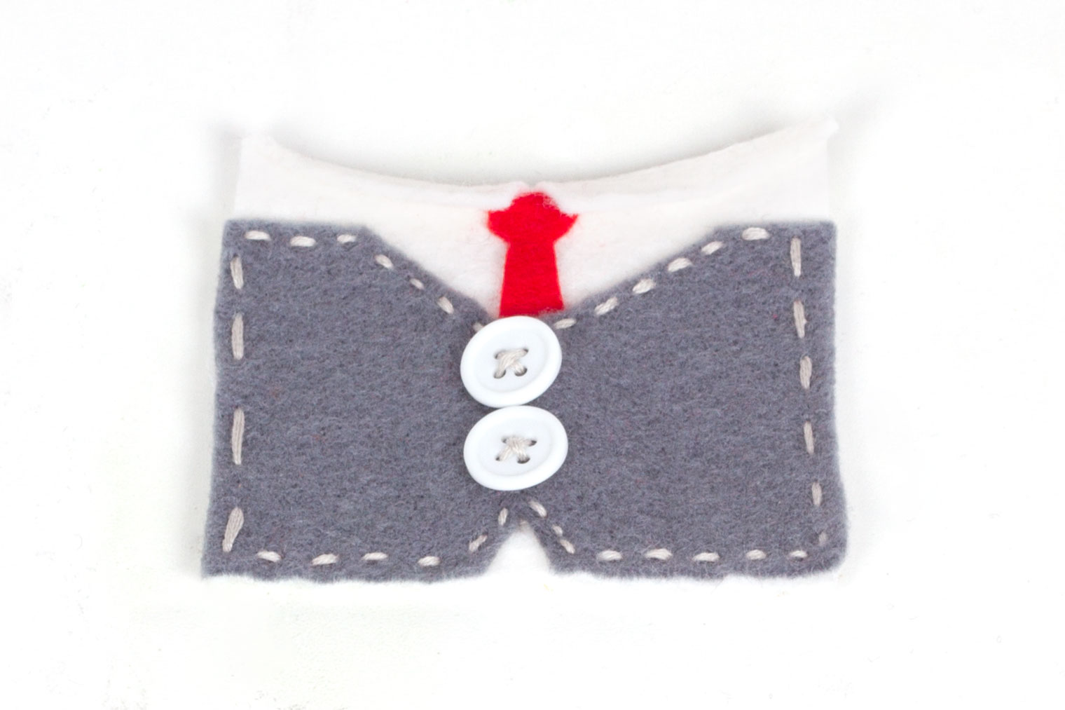 Step 2: Take the white piece of felt and either stitch or glue the red tie shape onto it (underneath the collar). Stitch the white buttons onto the centre of the grey felt shape, then sew the grey and white pieces together (grey on top).