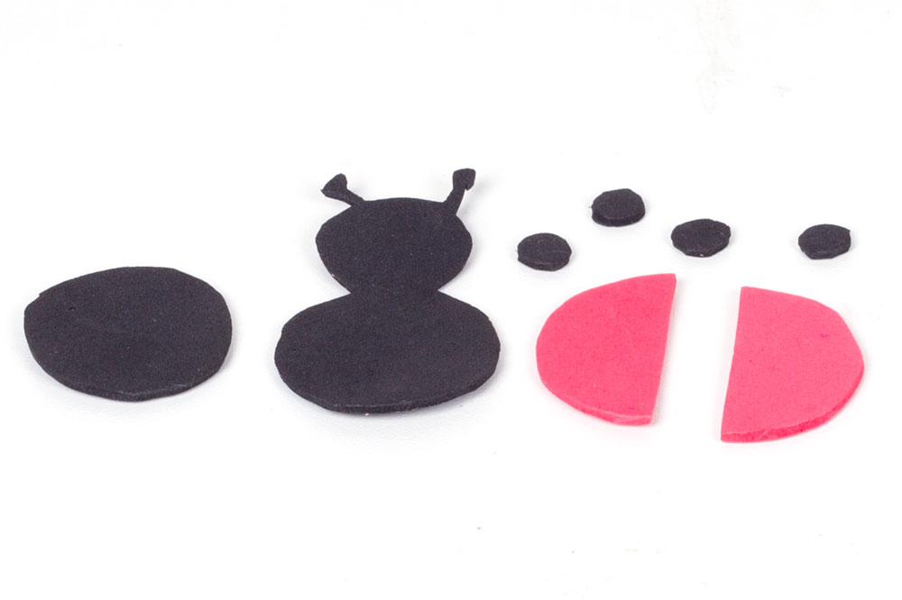 Step 2 Cut out the shapes for the ladybird from the foam sheets. This will include the body (black), a circle to stick behind the body (black), the wings (red) and the spots (black).