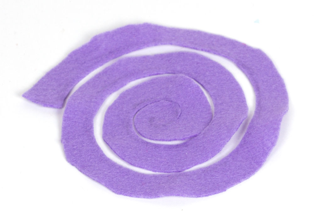 Step 1 To make the felt flowers, begin by cutting a piece of felt into a spiral with a diameter of approximately 15cm.