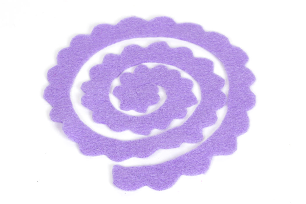 Step 2 Cut a scallop pattern on the outside edge of the entire spiral so it looks similar to the image above. If you want a different look to your felt flowers, such as more pointy petals, then shape the scalloped edge slightly differently.
