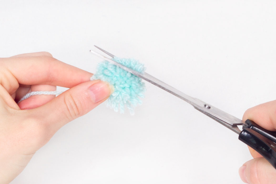 Step 5 Trim the ends of the wool to make the pom pom more of a rounded circular shape. 