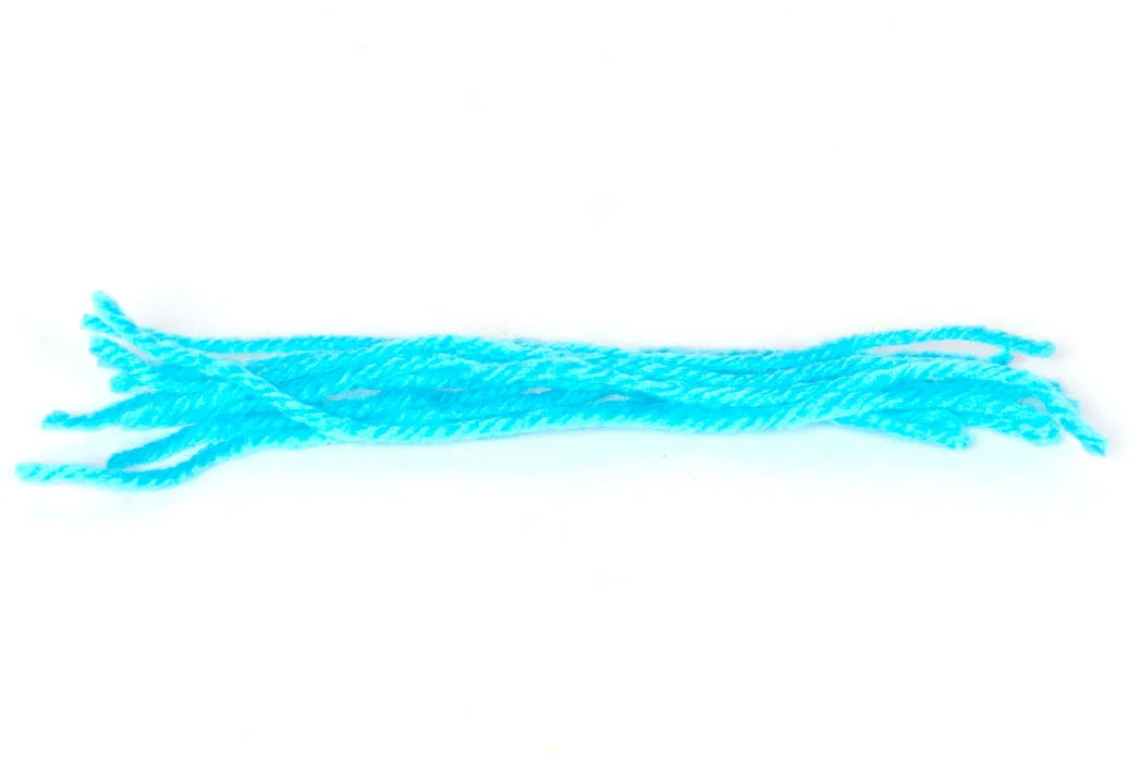 Step 2 Cut 20 strips of blue wool, about 12 cm long. For a fuller and thicker tassel try cutting a few more pieces of wool.