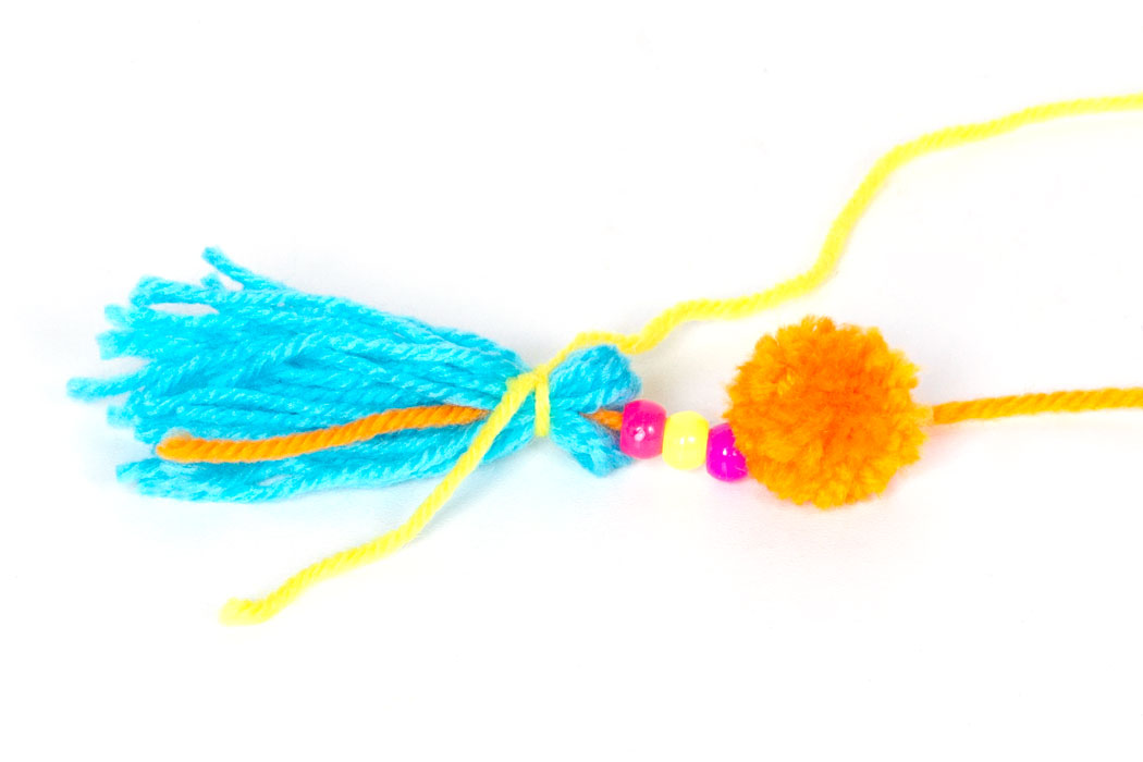 Step 3 Thread some colourful pony beads onto one end of the orange wool that is attached to the pom pom. Then hold all of the blue pieces of wool together and fold in half. Add the end of the orange wool to the folded blue wool, and then tie it all in place with some yellow wool as shown in the photograph above. Once the wool is tied in place you can trim the orange end so that it doesn't show in the tassel. Finally, wrap the end of the yellow wool around the tassel about six times and tie in place at the back. Then tie the other end of the orange wool (attached to the pom pom) to the metal keyring and your keyring is finished! Subscribe to my newsletter to receive fun craft ideas and freebies! Please note: this blog post contains affiliate links, however all opinions are my own and I only link to products that I personally recommend.