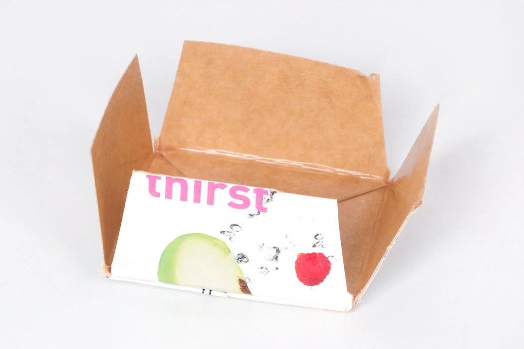 Step 2 Take the other end of the juice carton and measure about 4cm up from the bottom and cut. Then cut a slit down each corner leaving four flaps. Cut a small section off of the side edge of each flap, as shown in the image above.