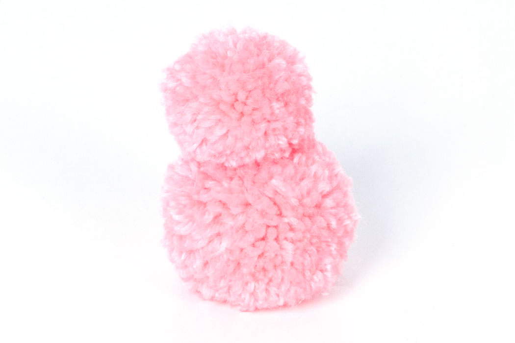 Step 2 Glue the smaller pom pom onto the larger one to create the head and body. Hold in place until the glue dries.