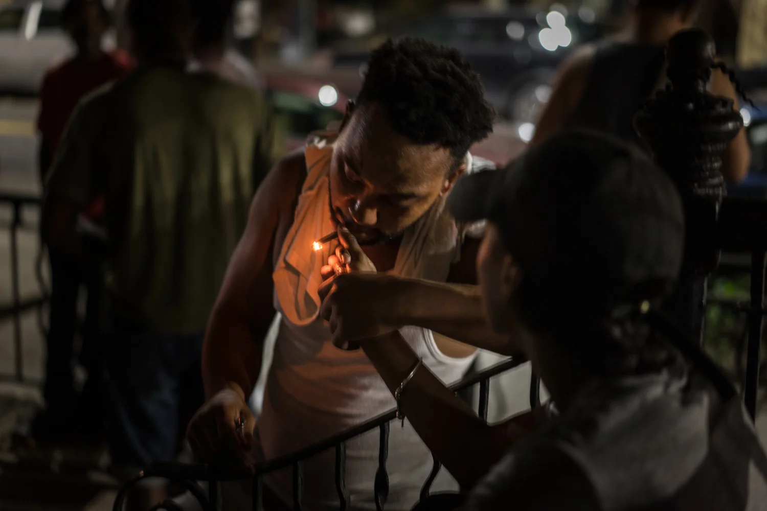 Fatboy (smoking) catches up with friends outside his family home before a dance battle event in the basement.