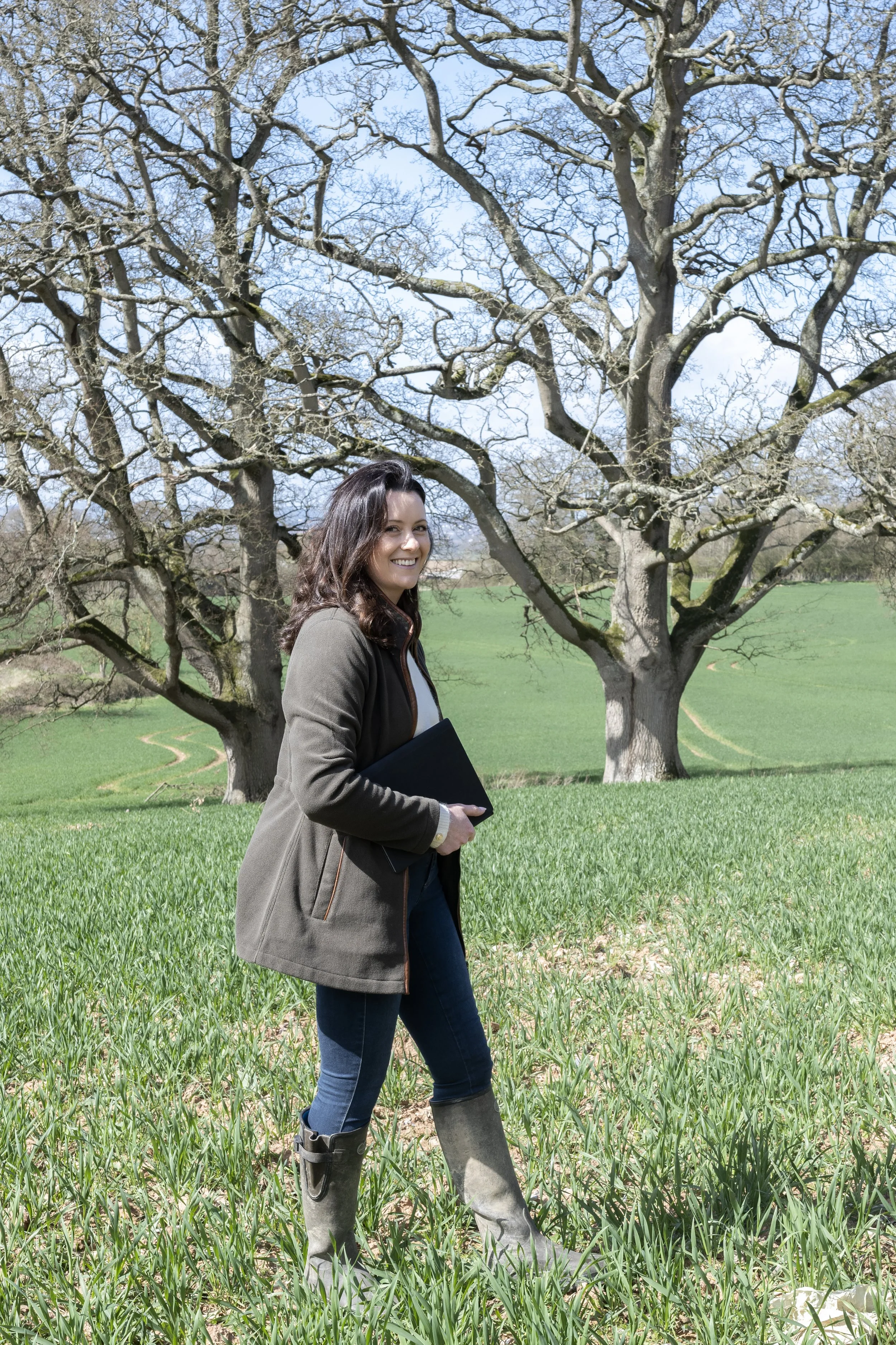Estate planner walking in the field with wellies on a sunny day