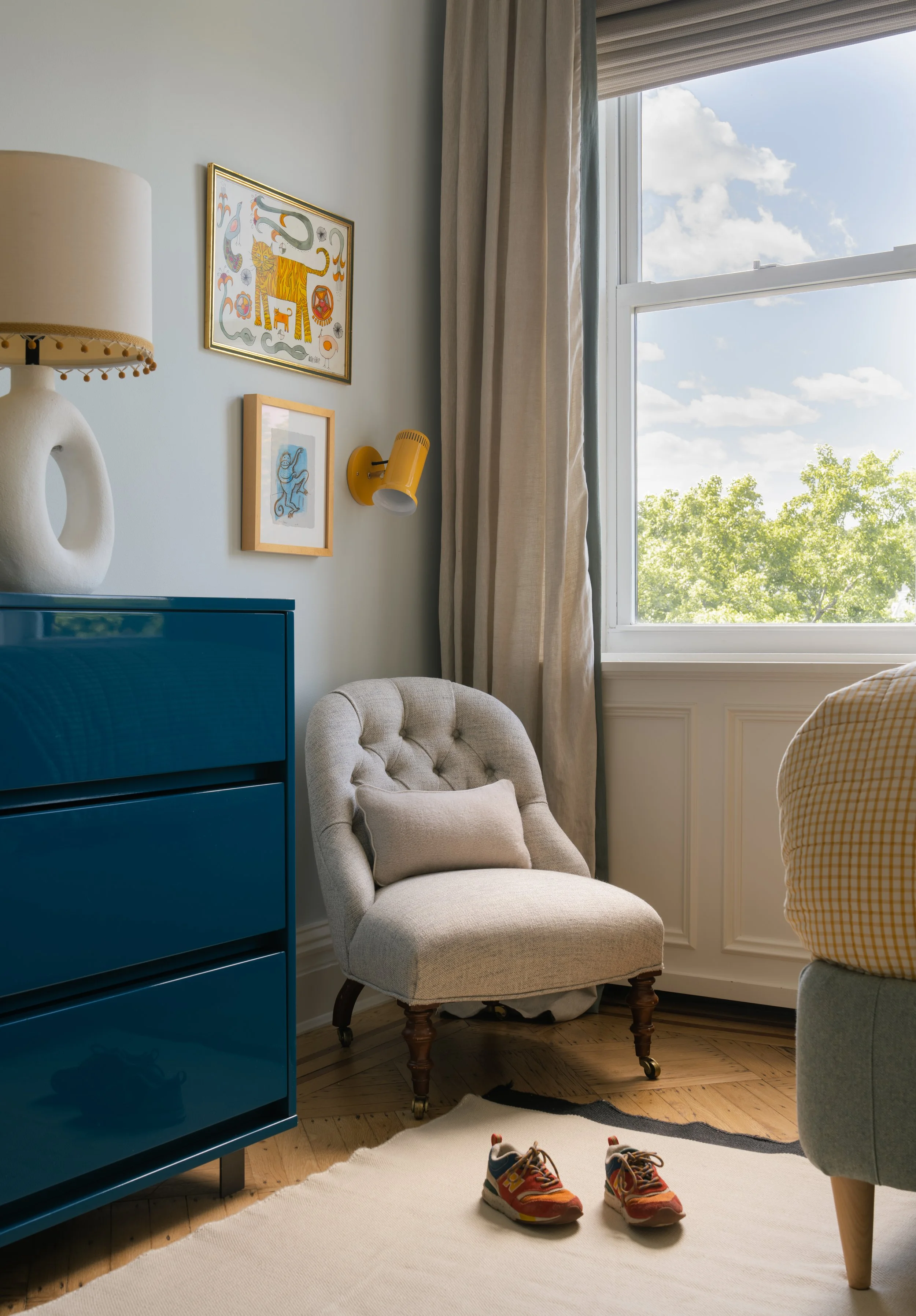 Corner of child's room with chair and royal blue dresser.