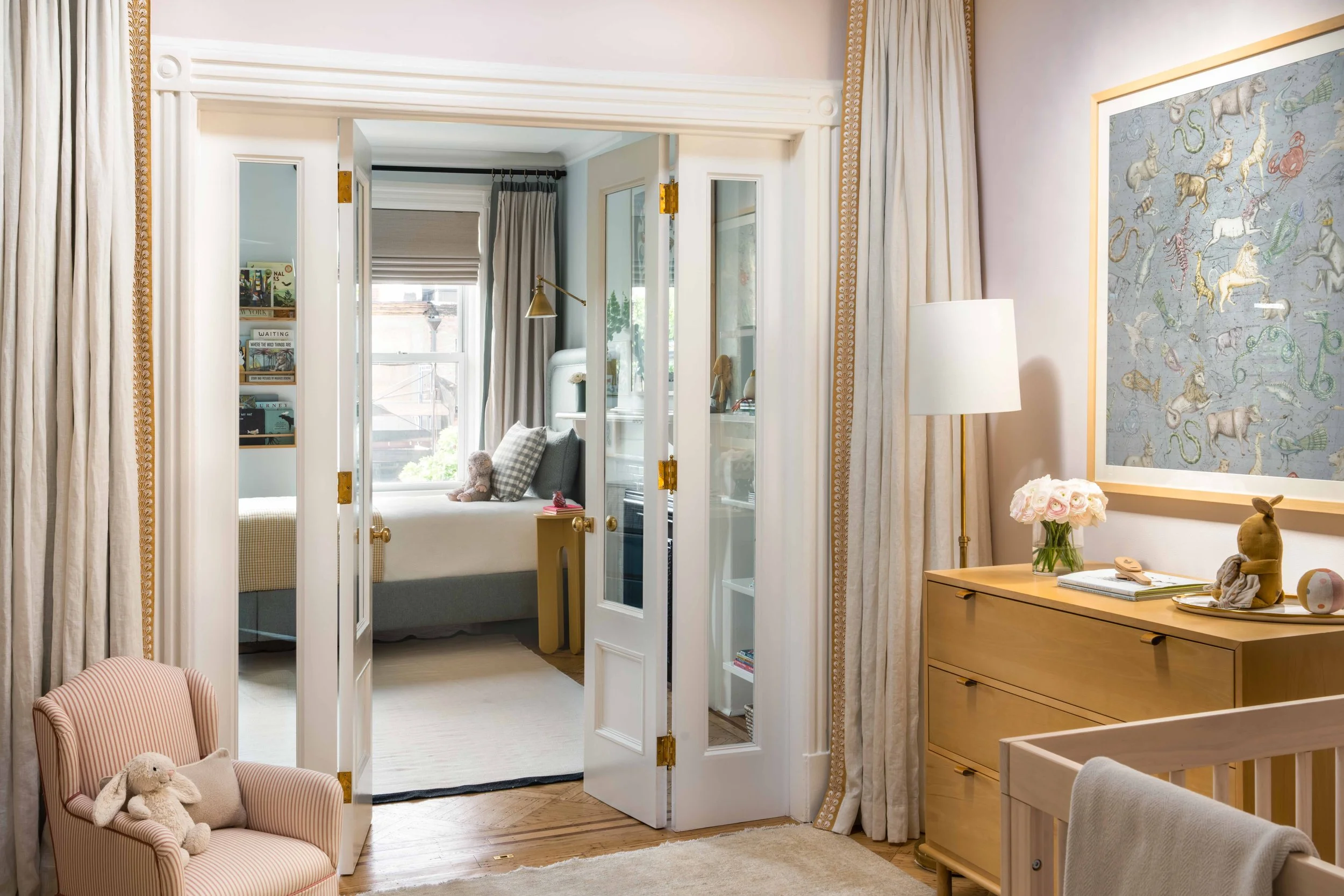 Nursery connected to children's room with double doors.