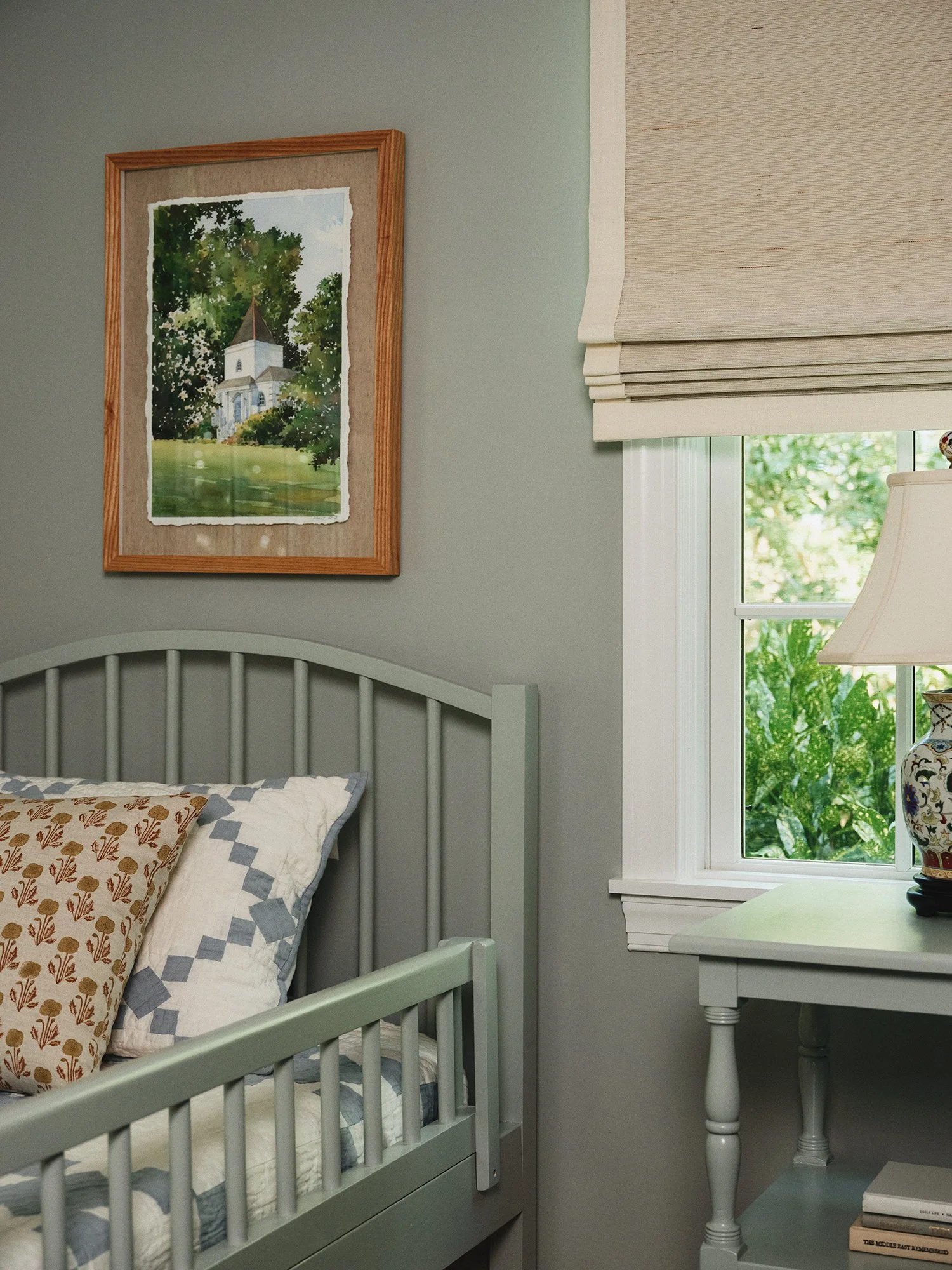 Child's bedroom with light green bed, walls, and furniture.