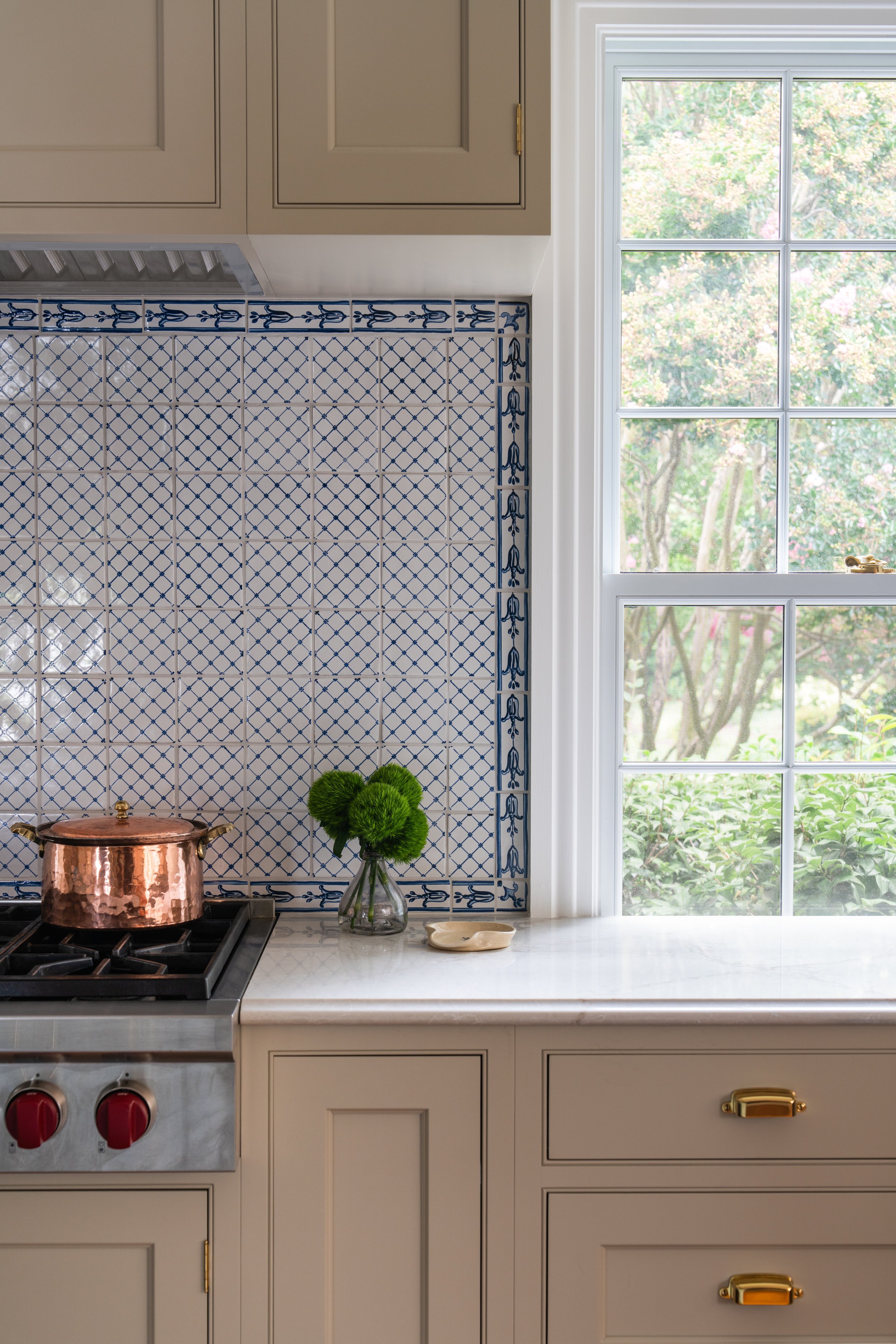 Close-up of kitchen backsplash, stove, and window.