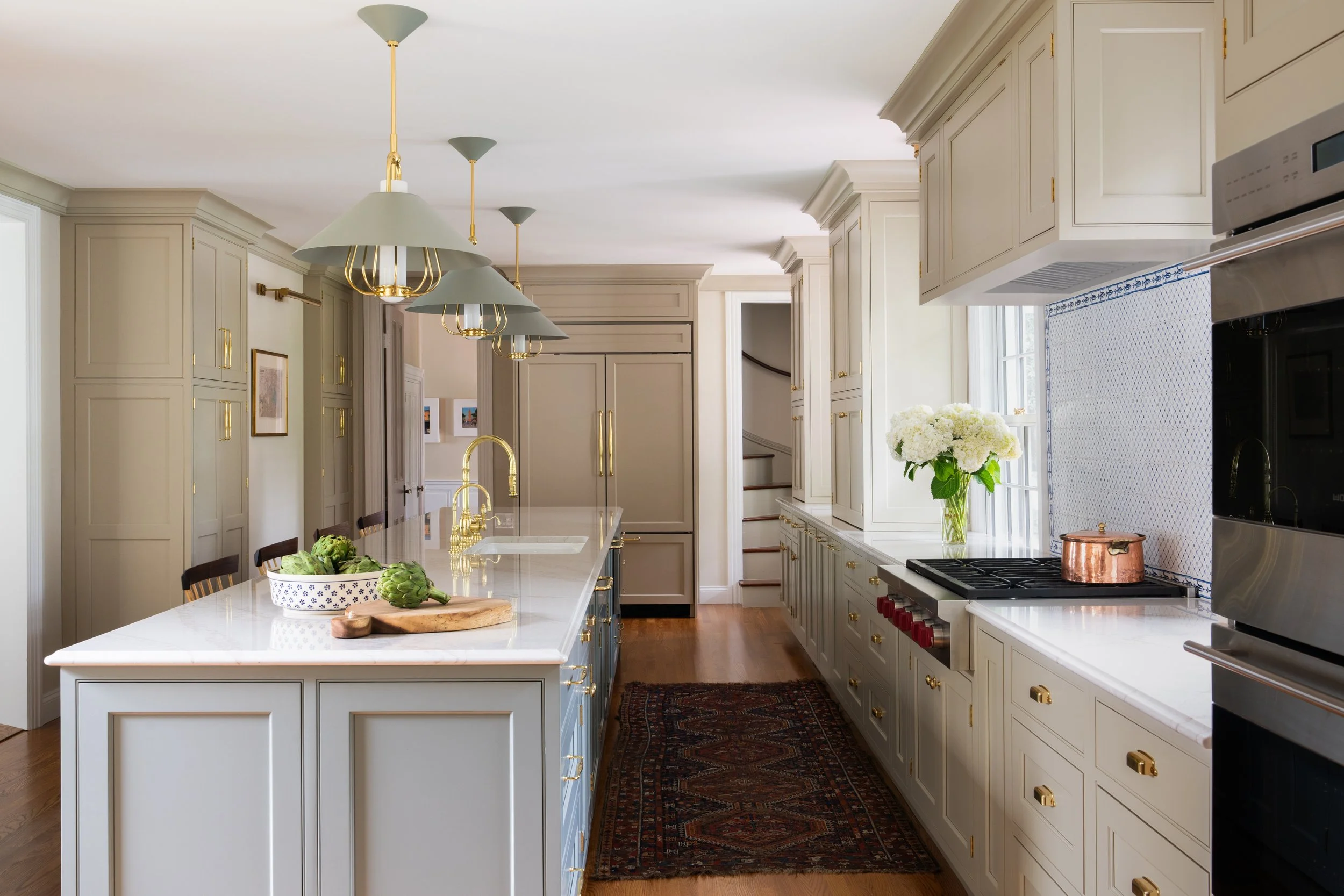 Brightly-lit kitchen with brass detailing.