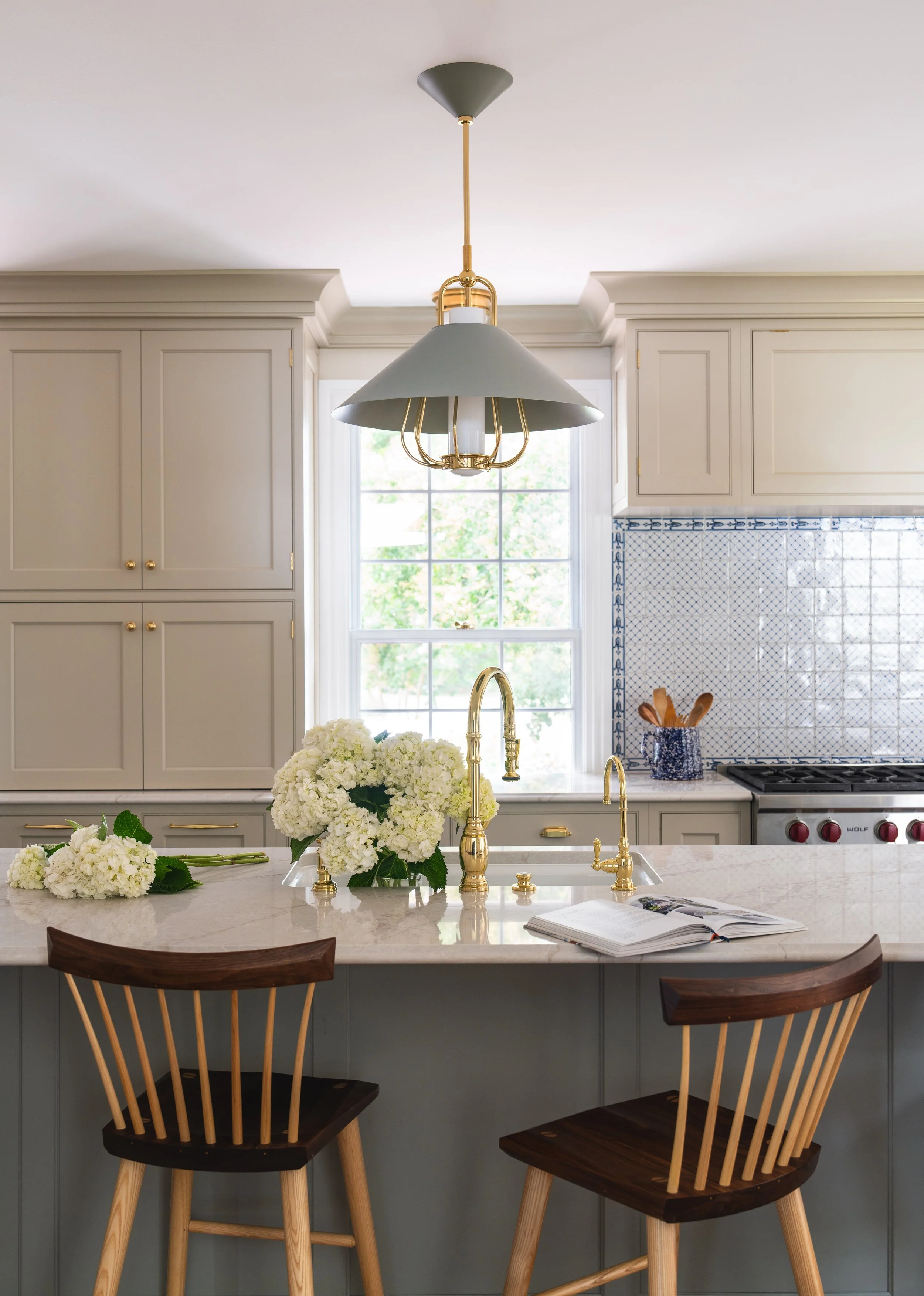 Kitchen island with wooden stools and flowers.