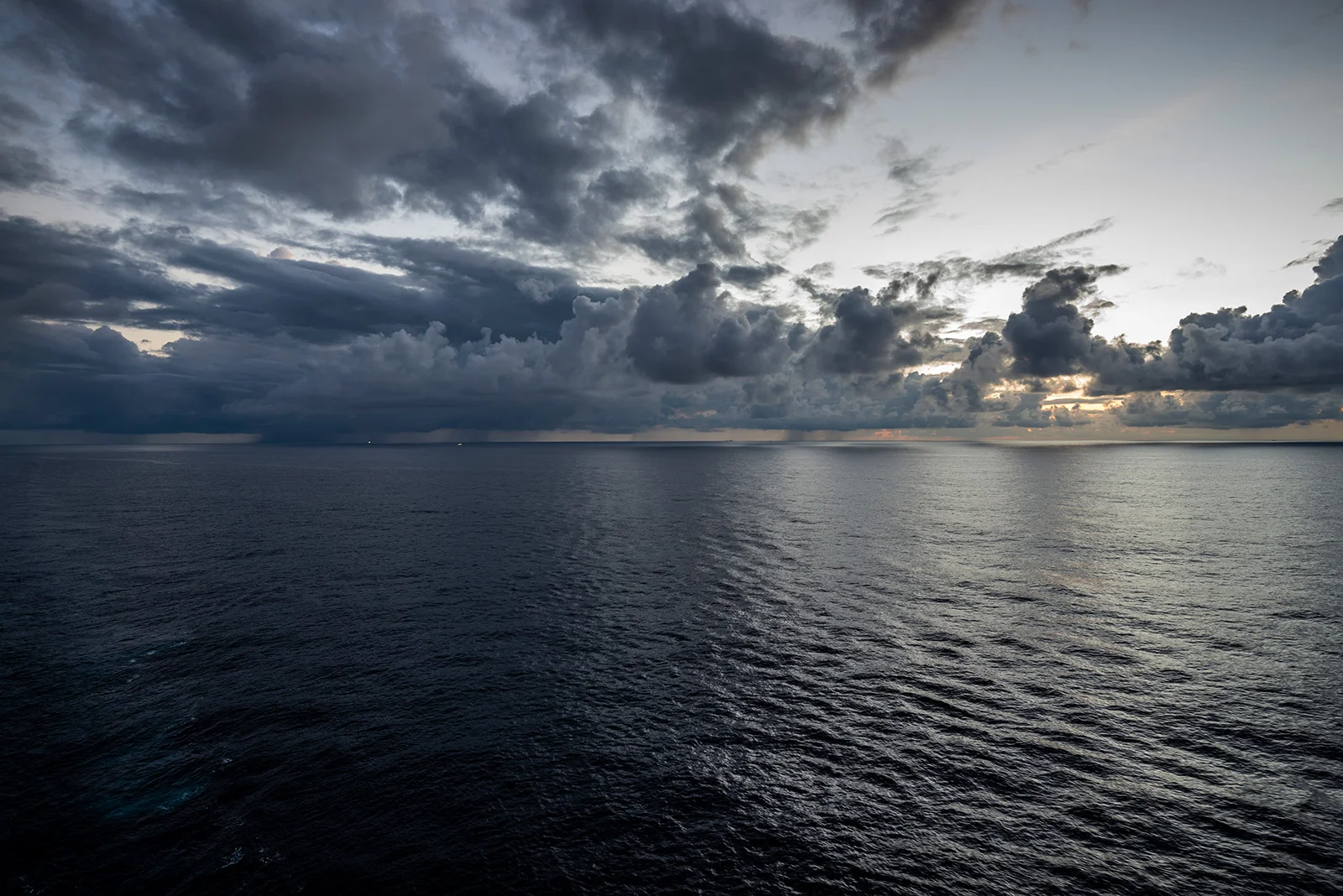 日出一反常态的没有色彩，如同水墨一样。隐约可见雨云下亮着灯的两艘船。（小图可能看不清）