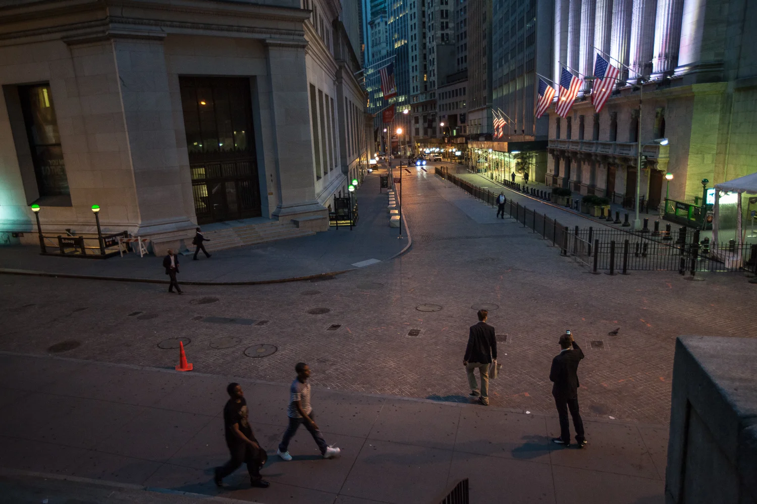People on Wall Street just before sunrise
