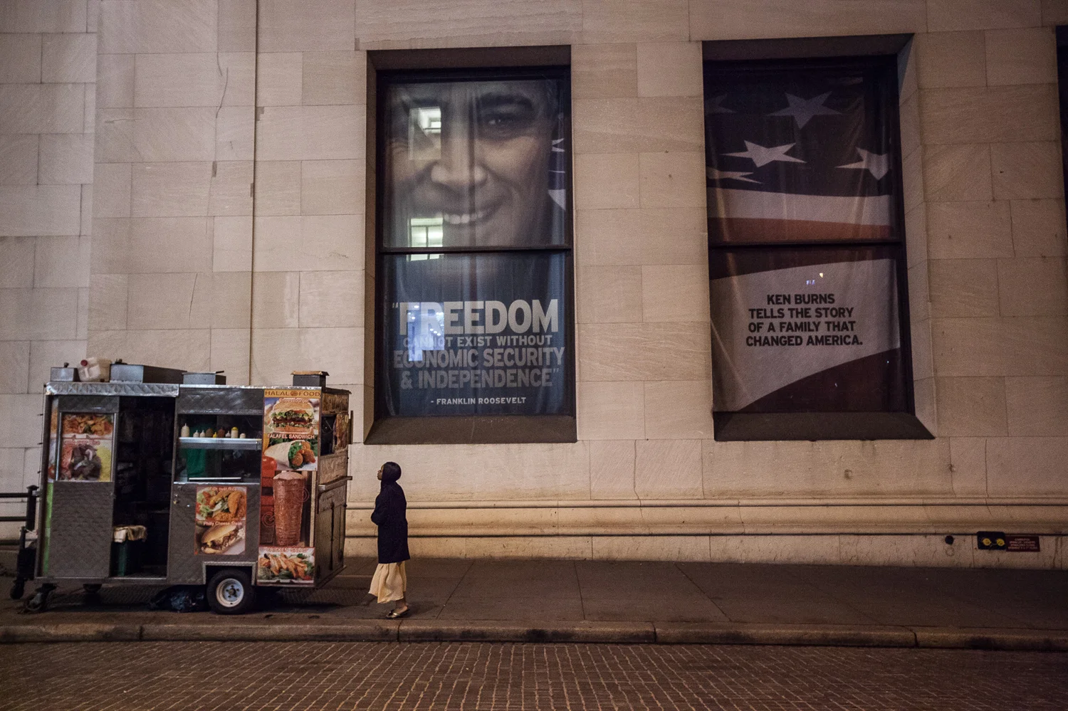 A woman in her nightgown, buying a cup of coffee from a cart on Wall Street at 5am