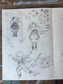 Page with hand-drawn sketches of a girl in different poses, musical notes, geometric shapes, and a speech bubble. The sketches depict a happy girl, a girl with glasses, and a girl singing or talking.