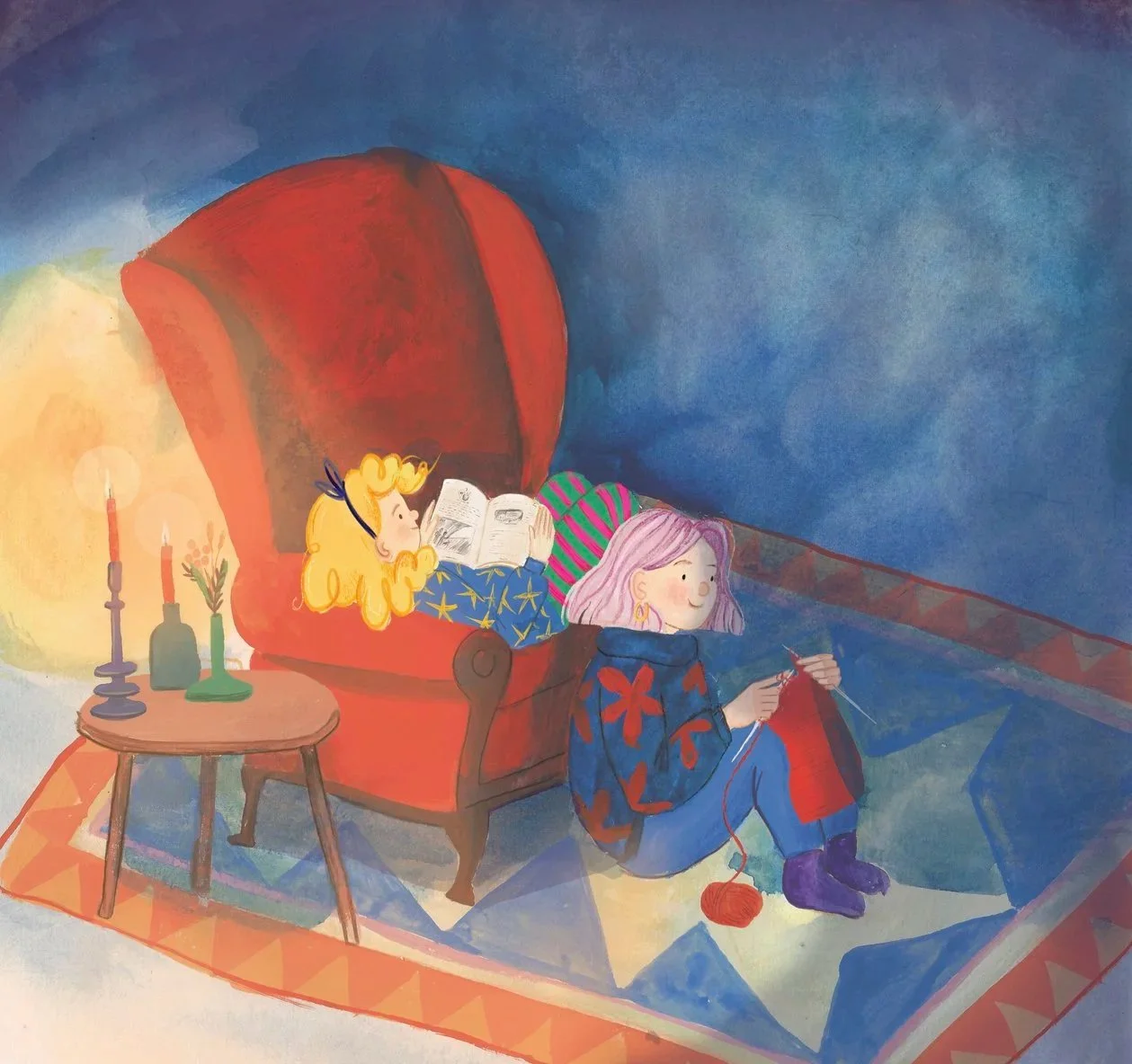 Two girls inside a cozy room, one with blonde hair reading a book on a red armchair, and the other with pink hair knitting on the floor, illuminated by a small table with candles and decorations.