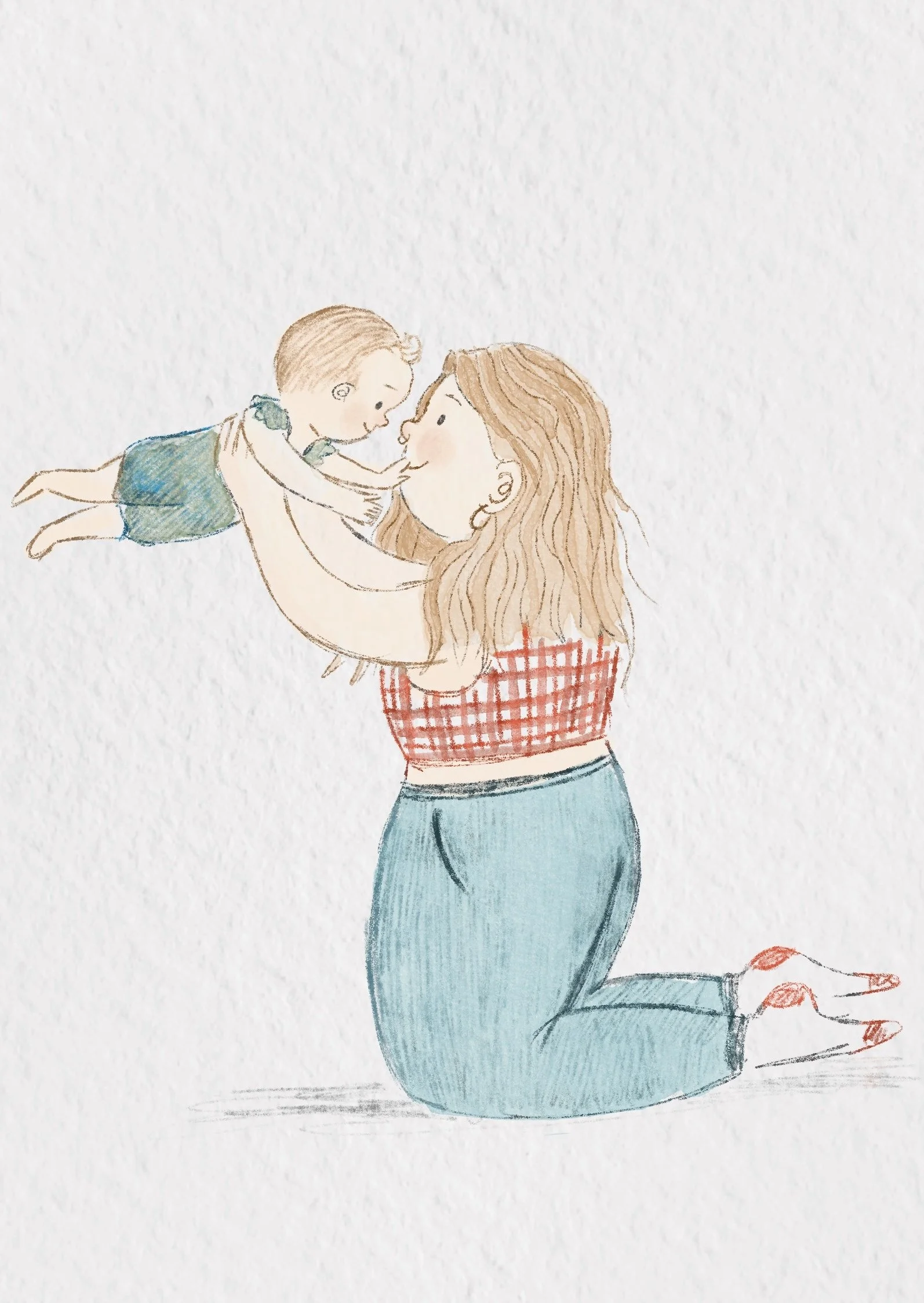 A woman with wavy hair kneeling and holding a young boy in the air, touching noses, with a white background.