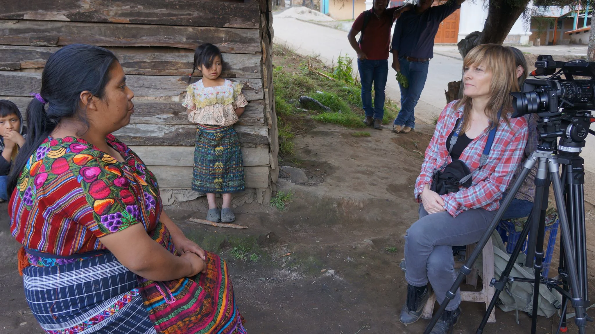 Jody Santos interviewing an indigenous woman in Guatemala as the woman’s daughter looks on