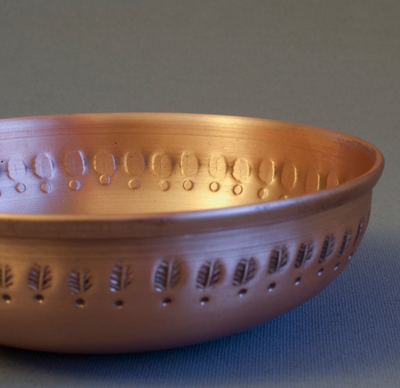 The  LEVANTE Copper Bowl Tealight Holde r with custom leaf-like motif.