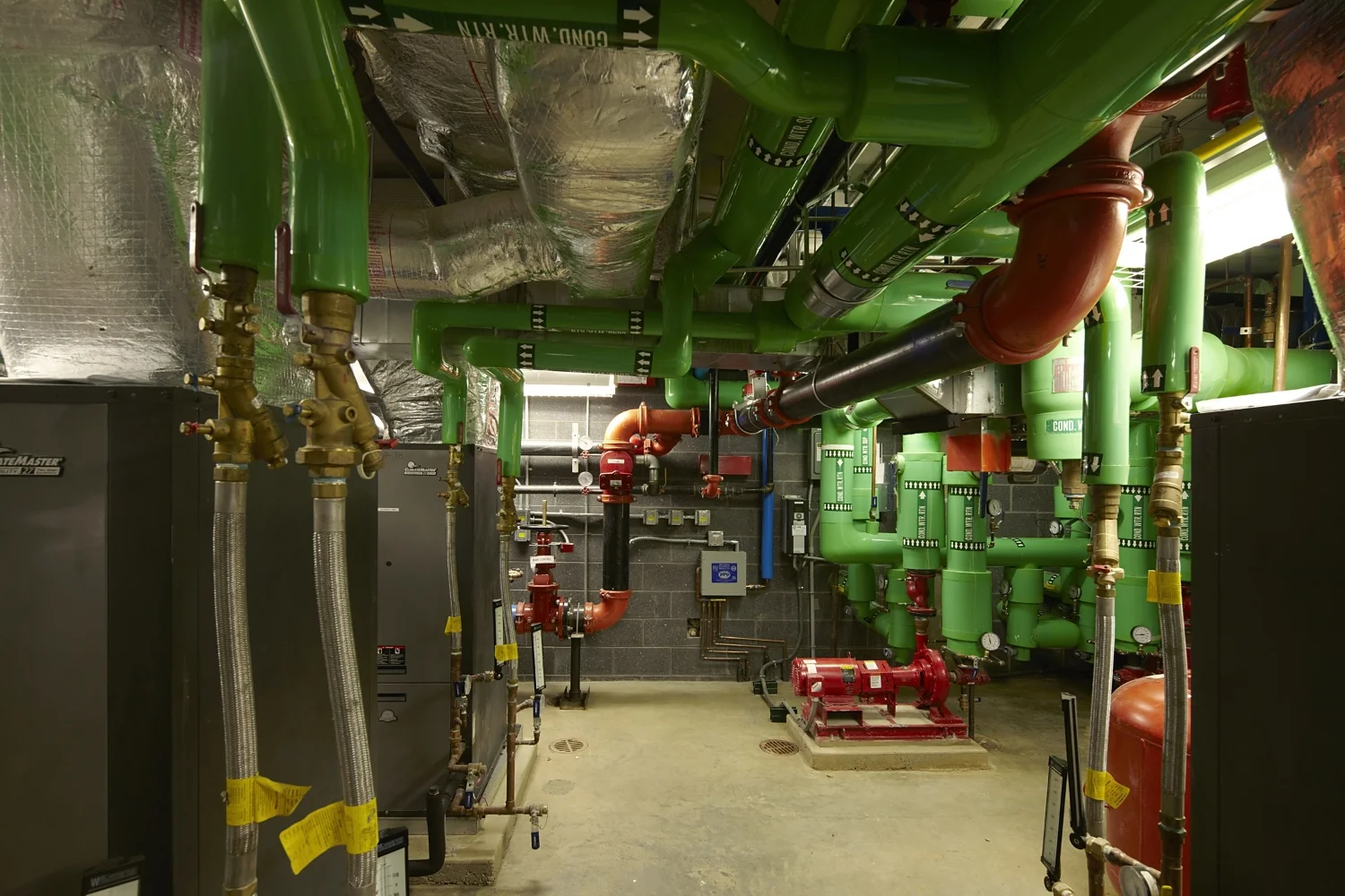 Geothermal heating and cooling system and base-mounted pumps