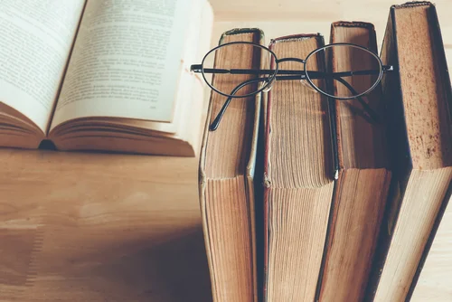 Row of Old Books and Reading Glasses