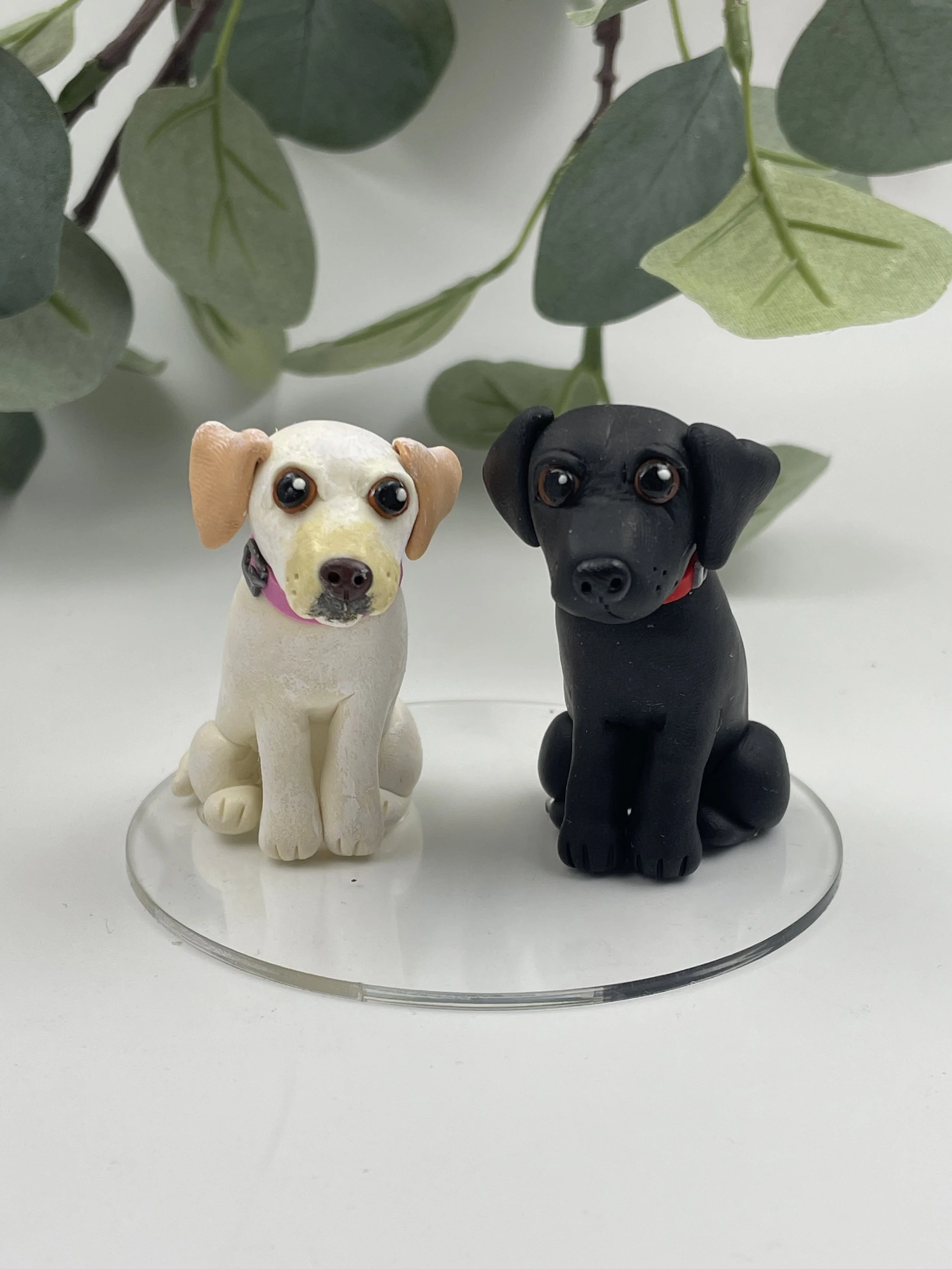 A polymer clay cake topper featuring two labrador retrievers, one black and one golden