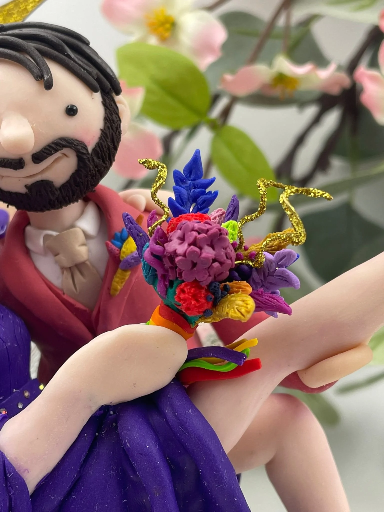 Close up of a polymer clay bouquet on a wedding cake topper