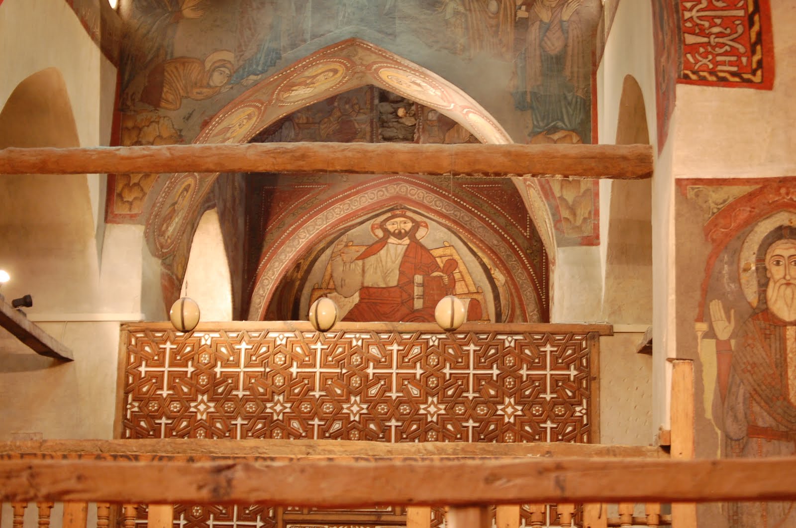 Looking towards the altar and the iconostasis (icon wall separating the congregation from the main altar). The white hanging orbs are ostrich eggs. Present in all Coptic churches, they represent the resurrection and rebirth in Christ. (Photo by author)
