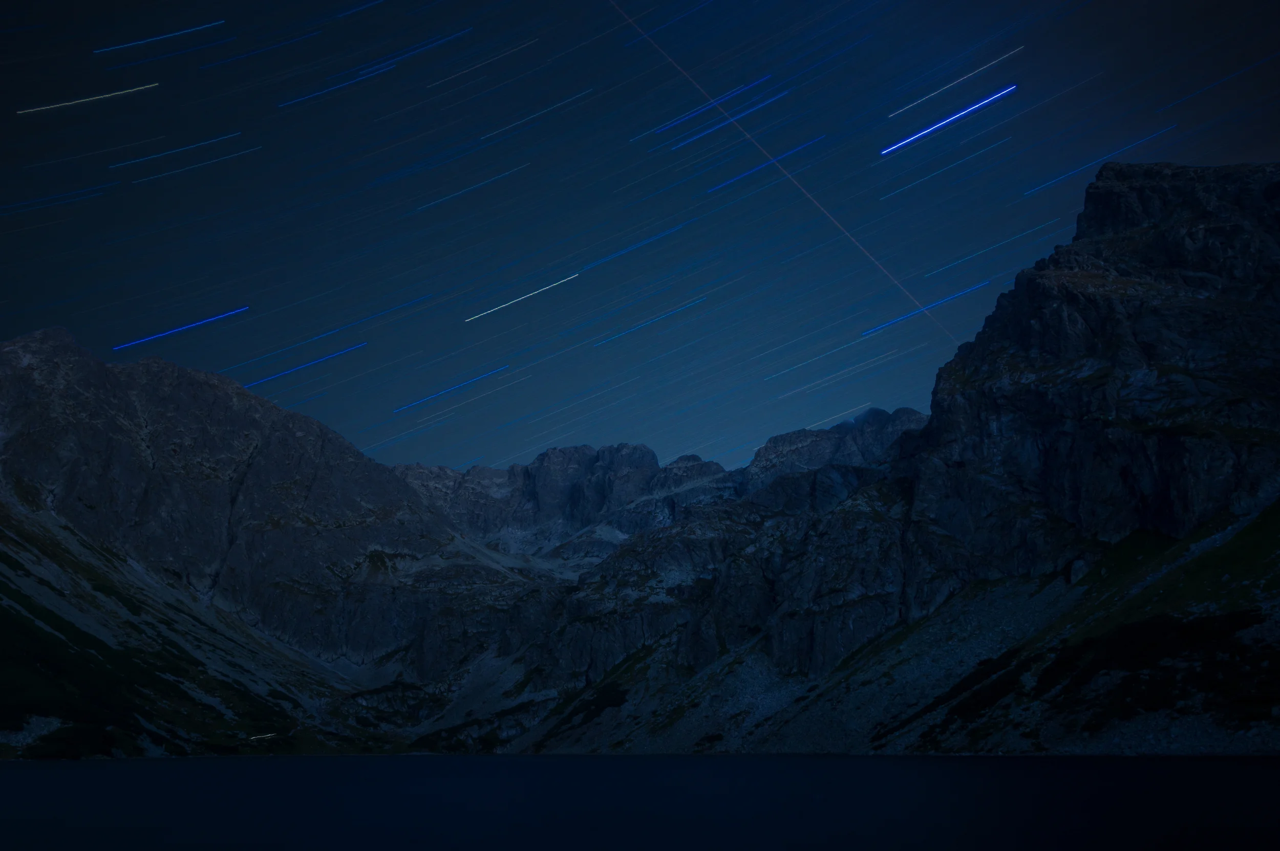 Star trails over Tatras and the last returning mountaineer with Headlamp