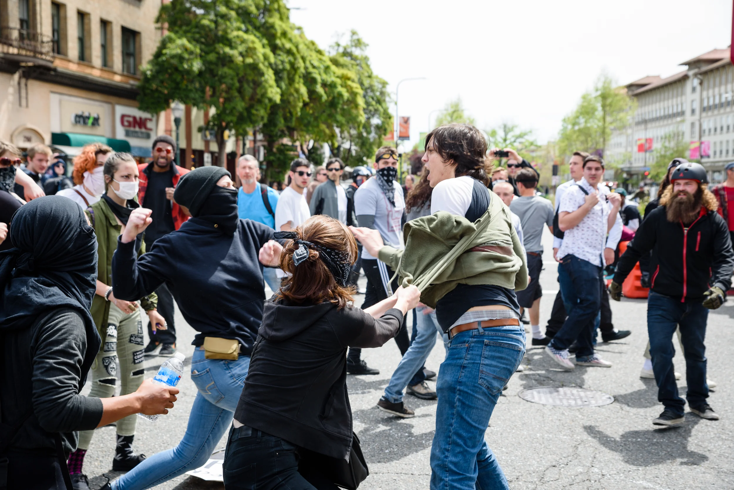 'Antifa' or Anti-fascists employ black bloc tactics during a Free Speech rally in Berkeley, CA, Here two of them are in a confrontation with a man who was holding a sign that read "Hate Speech is Free Speech" before it was stolen.