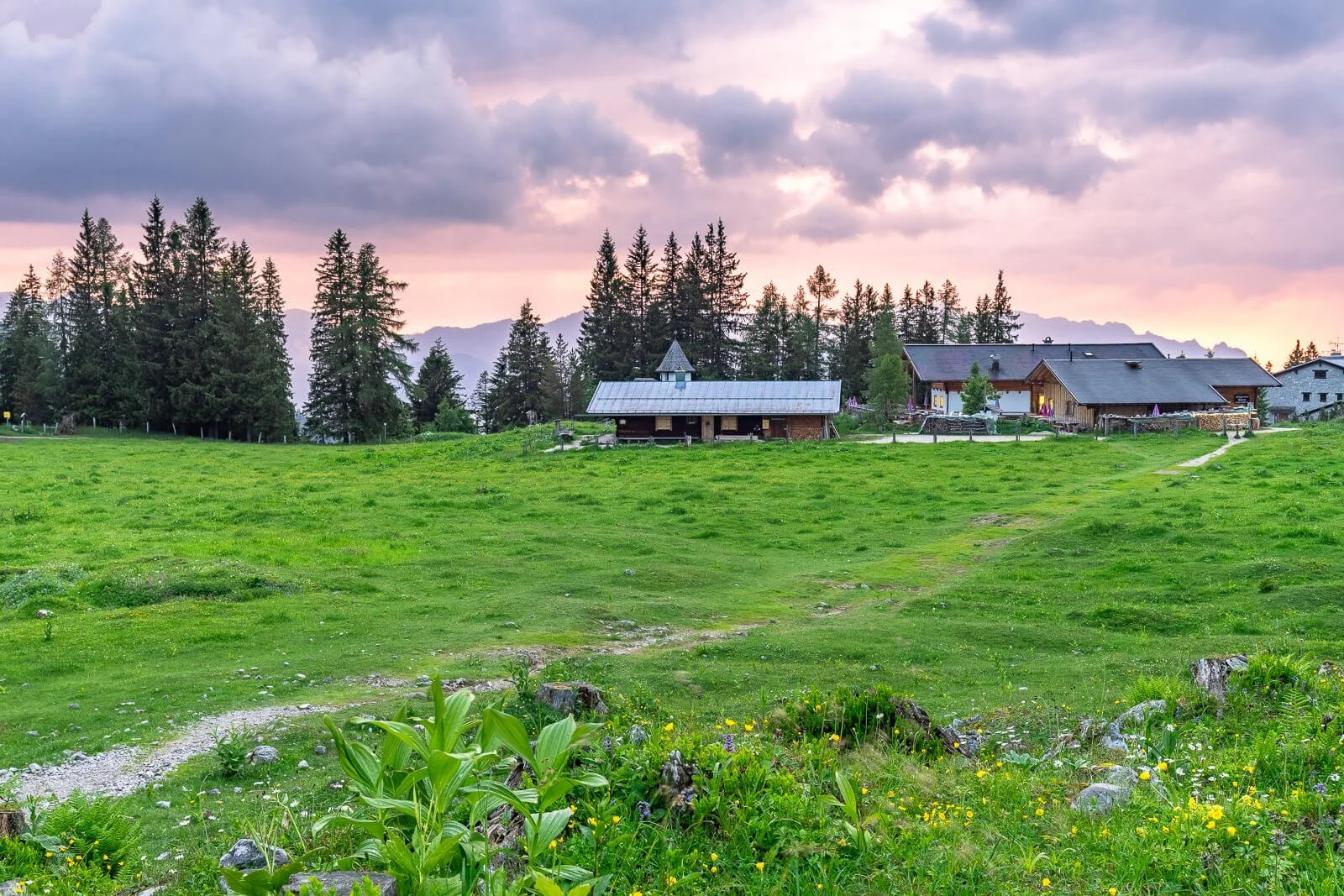Kührointalm im Berchtesgadener Land, Almwiese mit Hütten und Wanderweg in der Abendstimmung