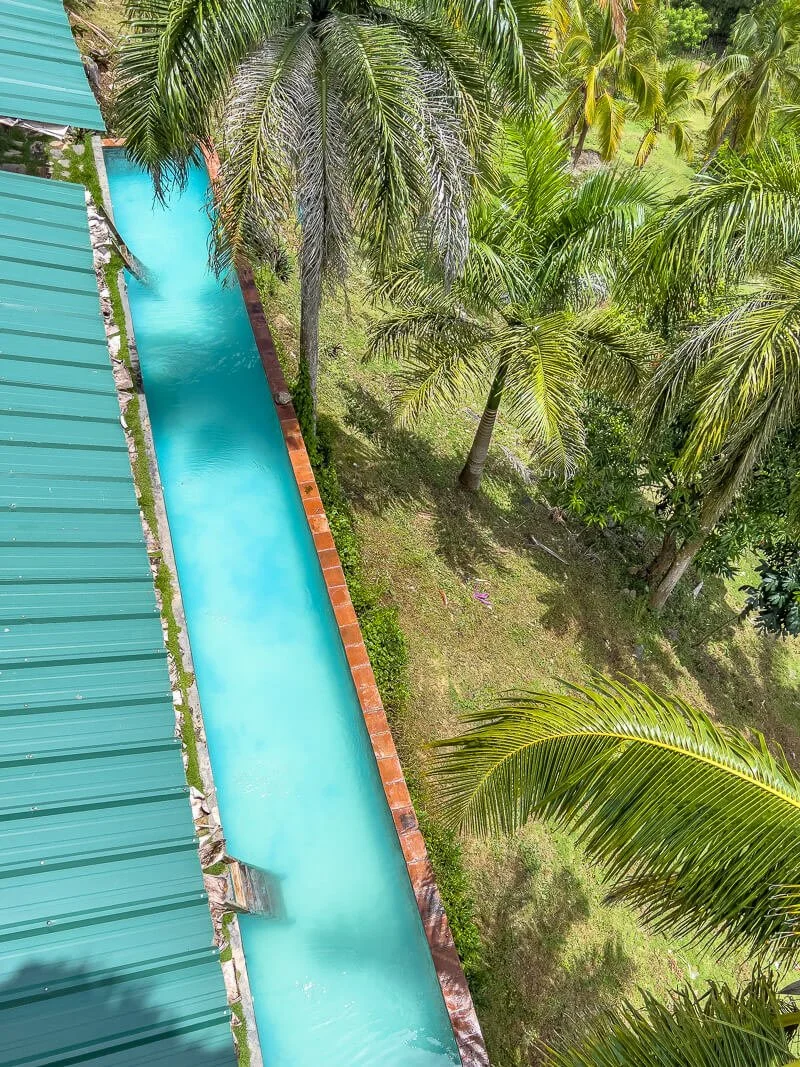  Pool der Hacienda Cocuyo bei Monte Rojo zwischen Palmen und tropischer Vegetation mit Blick auf die Unterkünfte 
