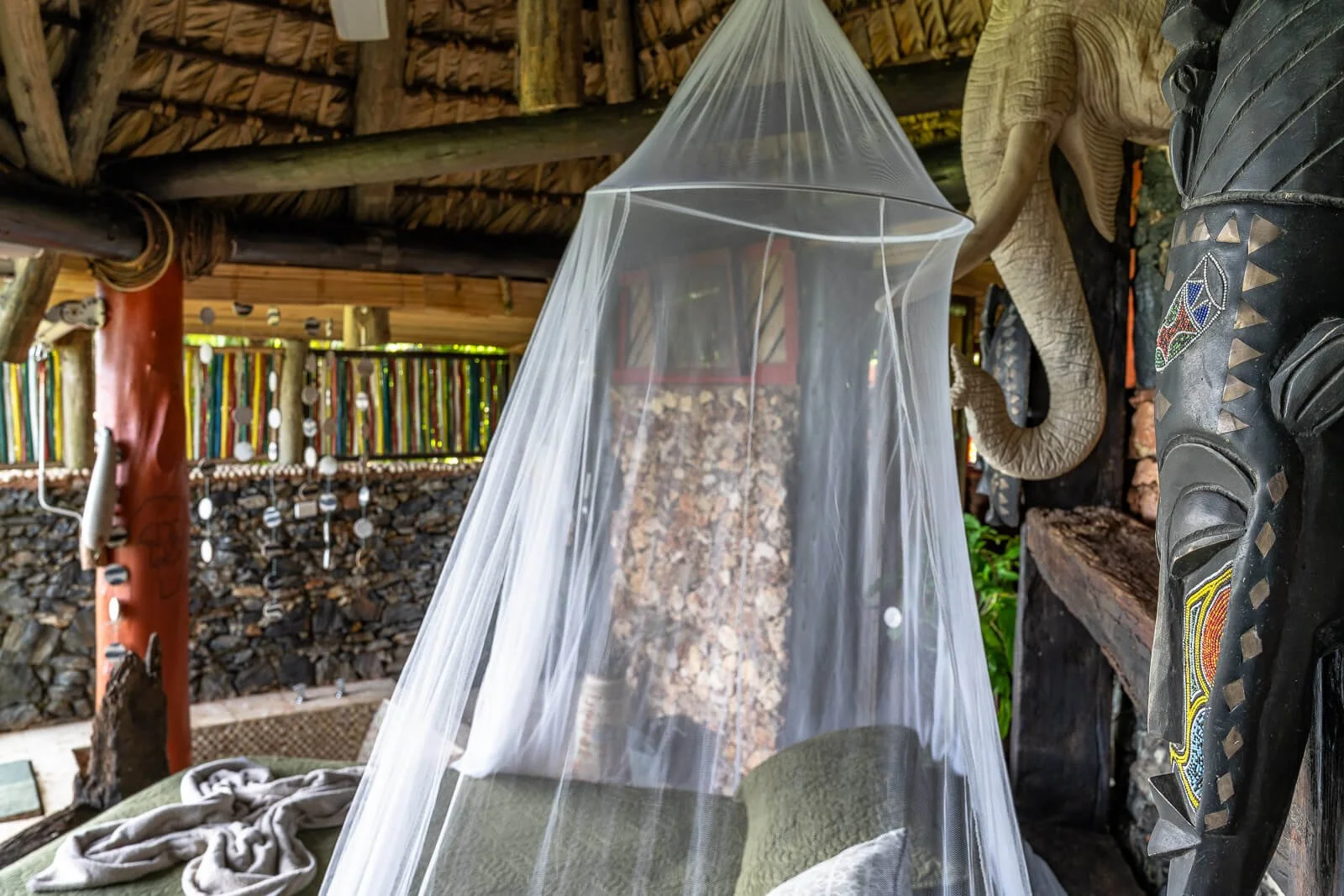  Schlafbereich im Casa El Paraíso bei Las Galeras mit Moskitonetz unter einem Palmendach 
