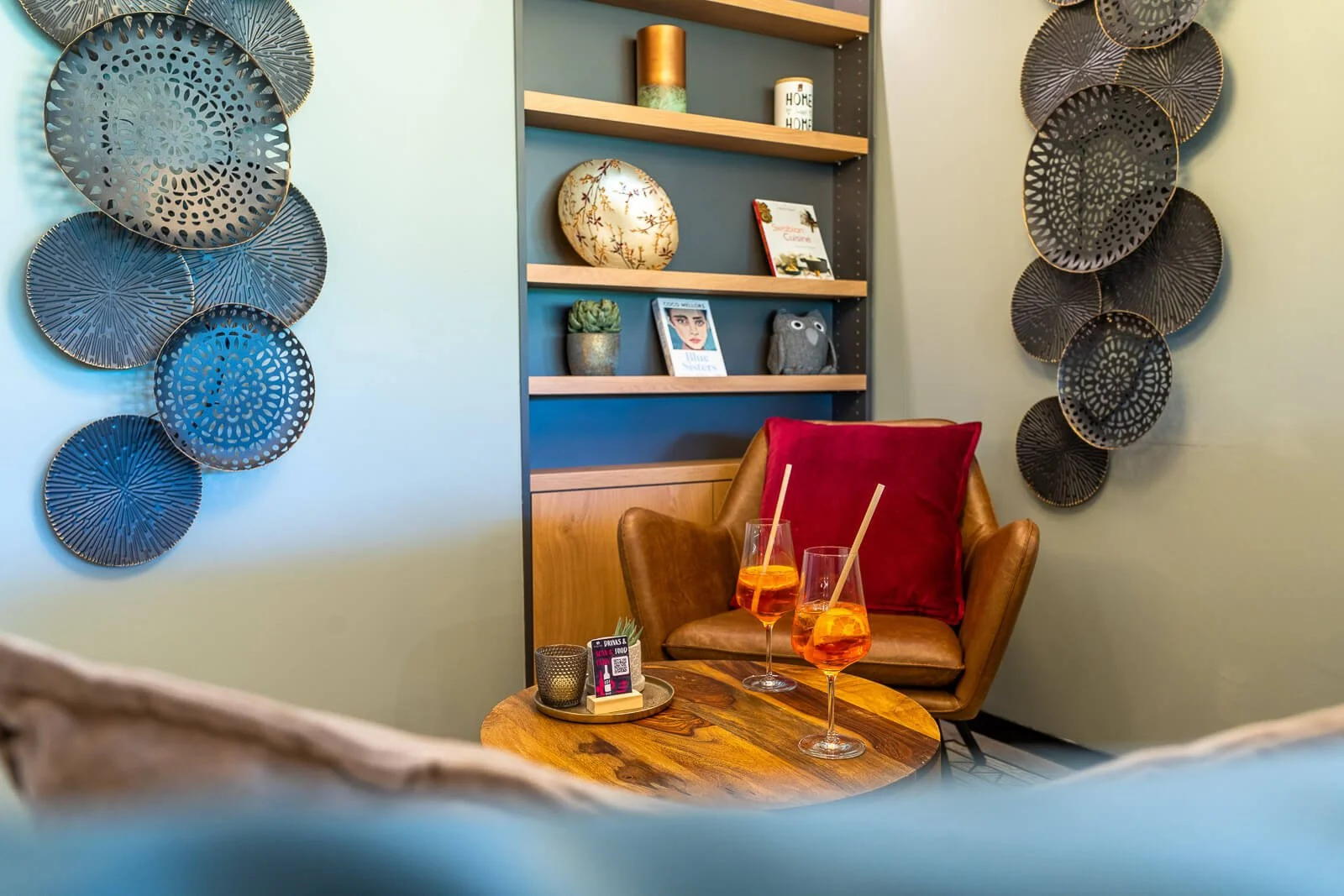 Gemütliche Hotellounge mit Design-Sesseln, Deko-Elementen und Aperitif-Getränken.