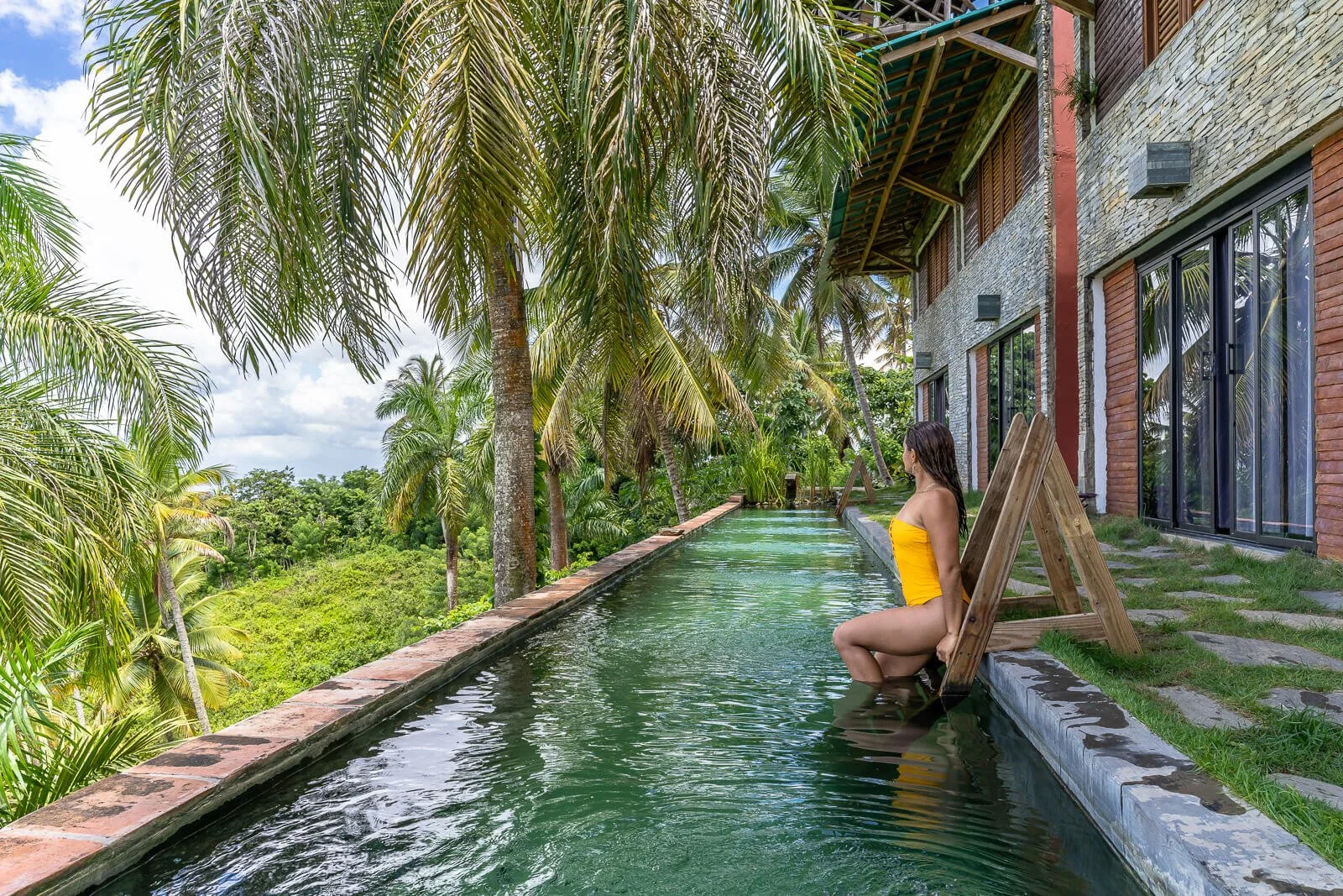 Gast sitzt am Rand eines schmalen Infinity-Pools einer Boutique-Unterkunft mit Blick in den tropischen Dschungel auf der Halbinsel Samaná.