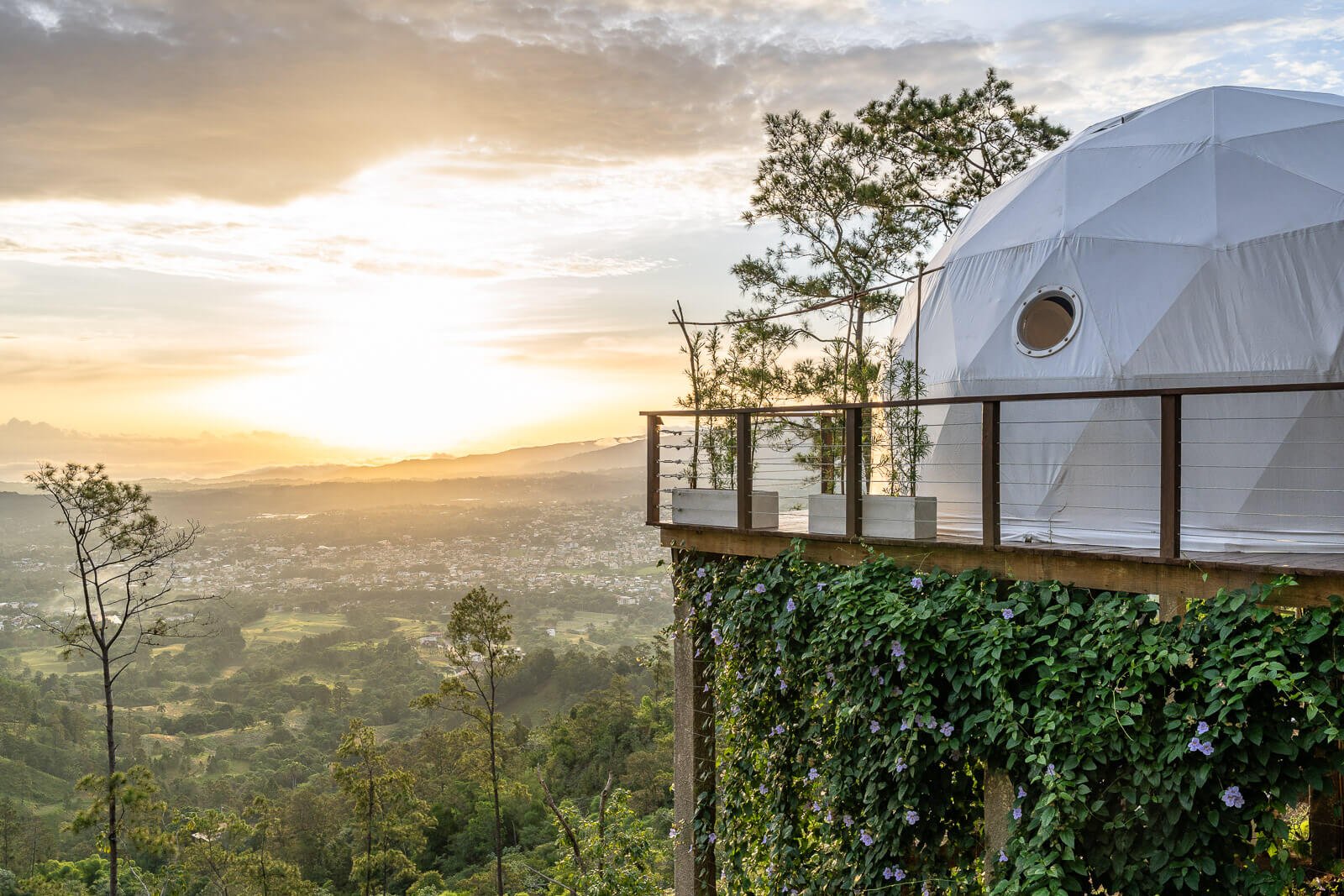 Luxuriöser Glamping-Dome auf einer Terrasse über der Stadt Jarabacoa in der Dominikanischen Republik bei Sonnenaufgang.