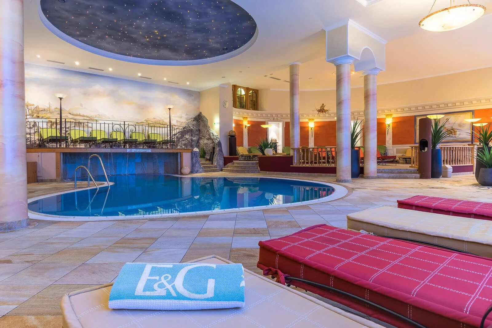 Innenaufnahme eines Wellnessbereichs mit Pool, Säulen und stimmungsvoller Beleuchtung in Tirol.