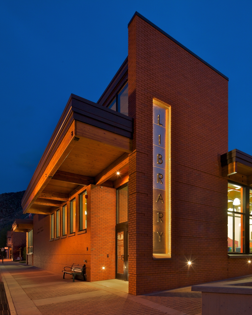 A side-lit sign marks the library's presence on the sidewalk