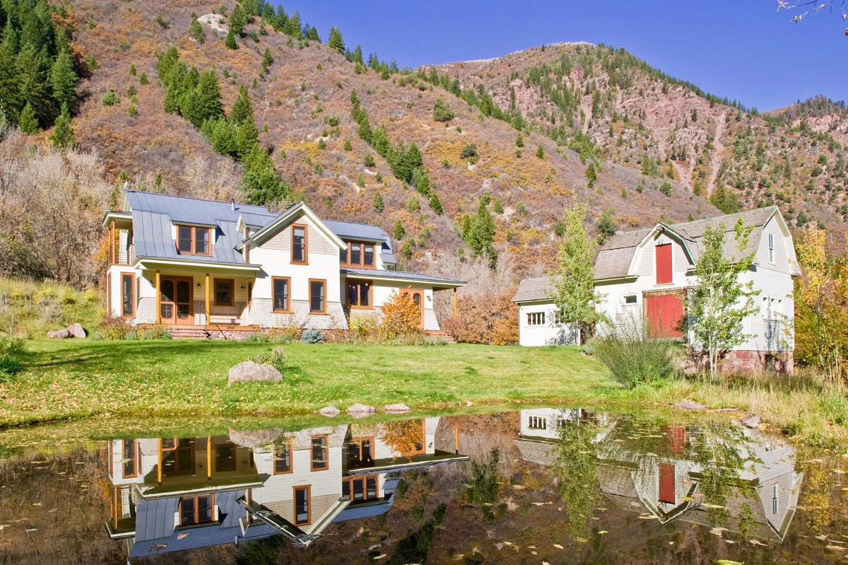 The house and barn reflected in the pond