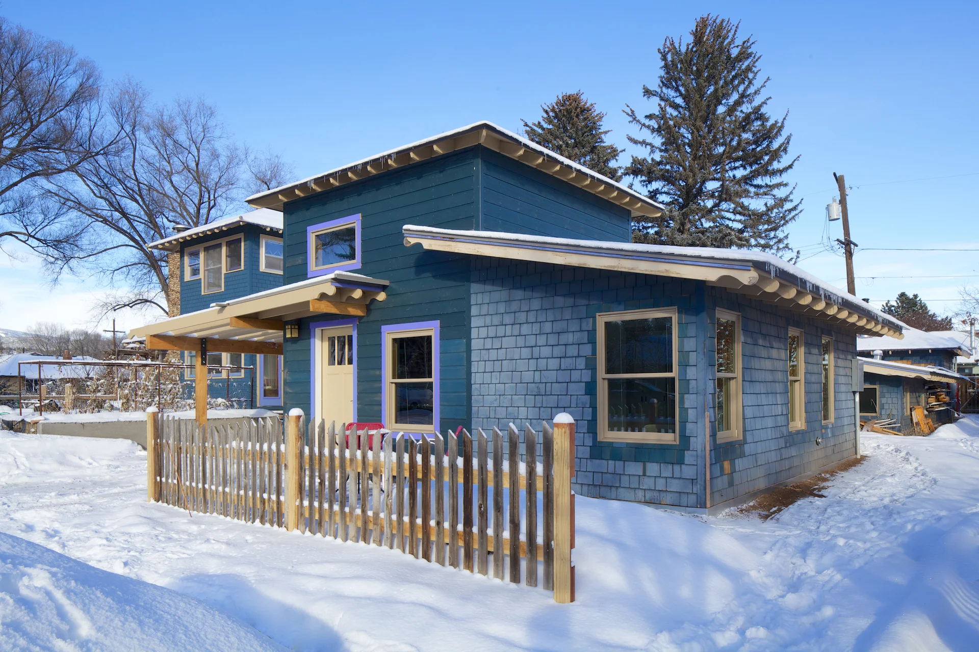 The newly painted addition includes a trellis structure which creates a covered entry over the front door.